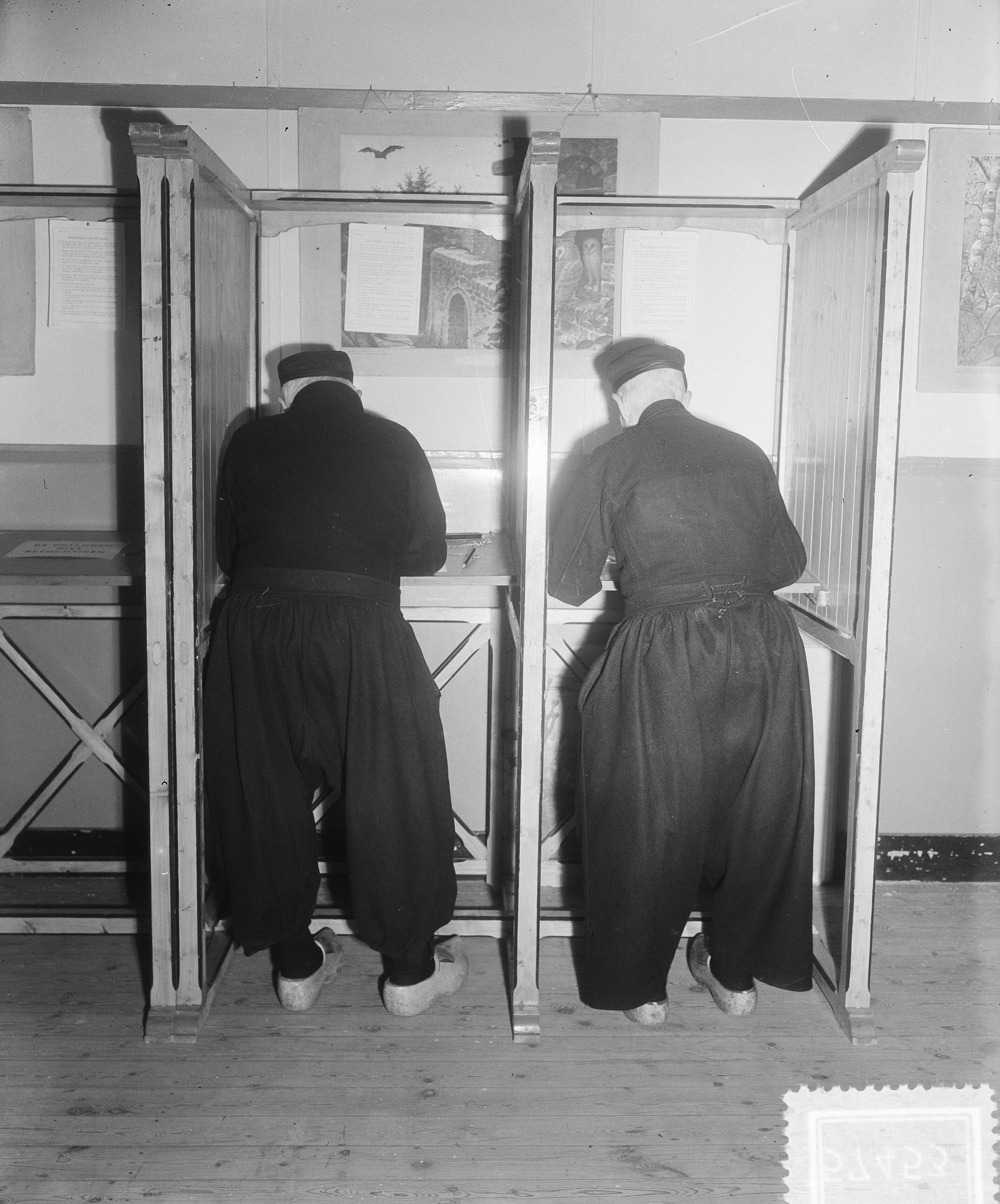 Gemeenteraadsverkiezingen 1953 — Stemmen voor gemeenteraden. Stembureau in Volendam — Foto: Pot, Harry / Anefo. Licentie: Set B: Rechtenvrij / Publiek Domein. Bron: Nationaal Archief. http://hdl.handle.net/10648/a90cac04-d0b4-102d-bcf8-003048976d84