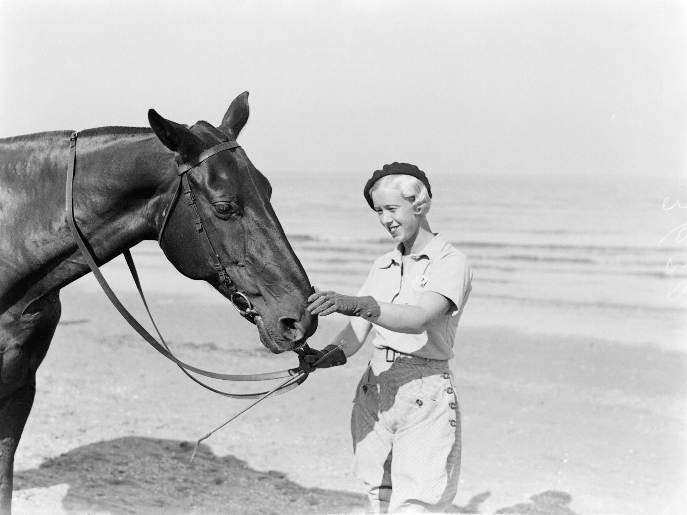 Scheveningen. — Een vrouw (Yvonne?) met een paard man op het strand in Scheveningen — Foto: Poll, Willem van de. Licentie: Set B: Rechtenvrij / Publiek Domein. Bron: Nationaal Archief. http://hdl.handle.net/10648/ae9aba62-d0b4-102d-bcf8-003048976d84