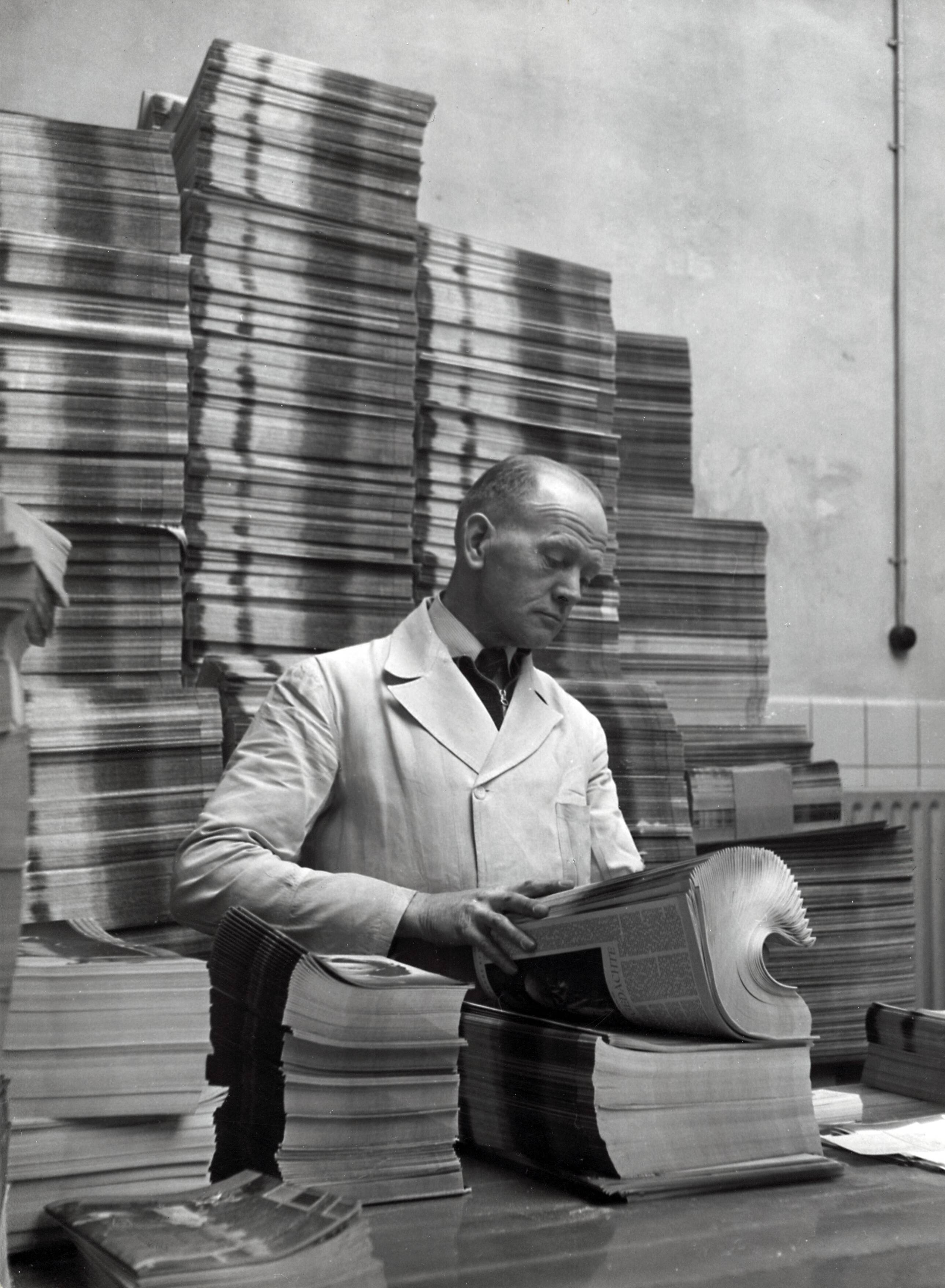 Collectie nader te bepalen — [Serie Bedrijfsvoering Spaarnestad] [man bezig met het collationeren van tijdschriften in een expeditieruimte] — Foto: Fotograaf Onbekend / Fotobureau onbekend / Spaarnestad Photo (05887). Licentie: Set B: Rechtenvrij / Publiek Domein. Bron: Nationaal Archief. http://hdl.handle.net/10648/35429da6-42a4-a382-e063-6df0900a6686