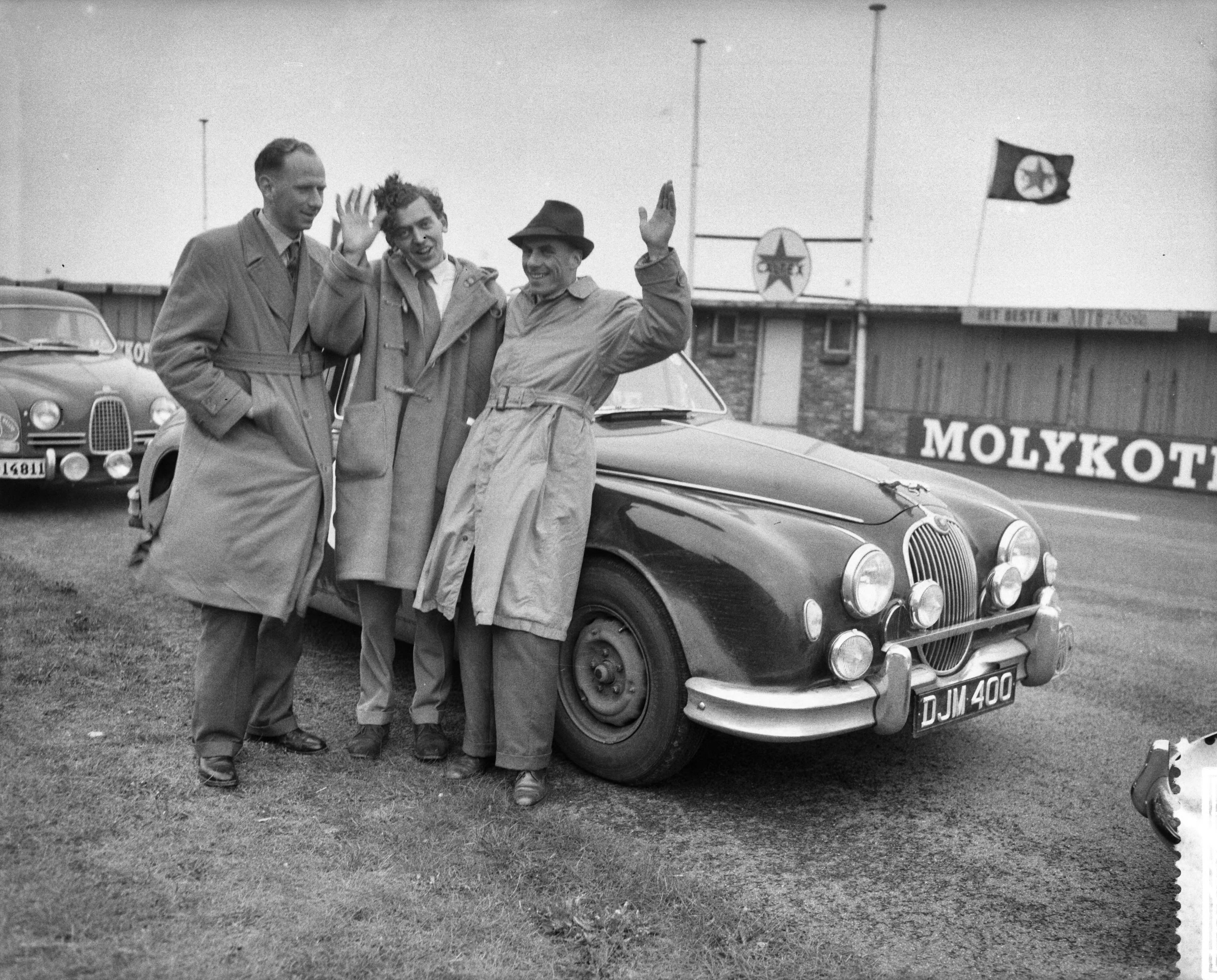 Tulpenrallye 1959 — Tulpenralley, einde op het circuit van Zandvoort. Algemeen winnaar , v.l.n.r. G. E. Morley , W. B. Hercock (monteur?) en D. J. Morley met achter hen de Jaguar 3.4 — Foto: Behrens, Herbert F. / Anefo. Licentie: Set B: Rechtenvrij / Publiek Domein. Bron: Nationaal Archief. http://hdl.handle.net/10648/a992dd2e-d0b4-102d-bcf8-003048976d84