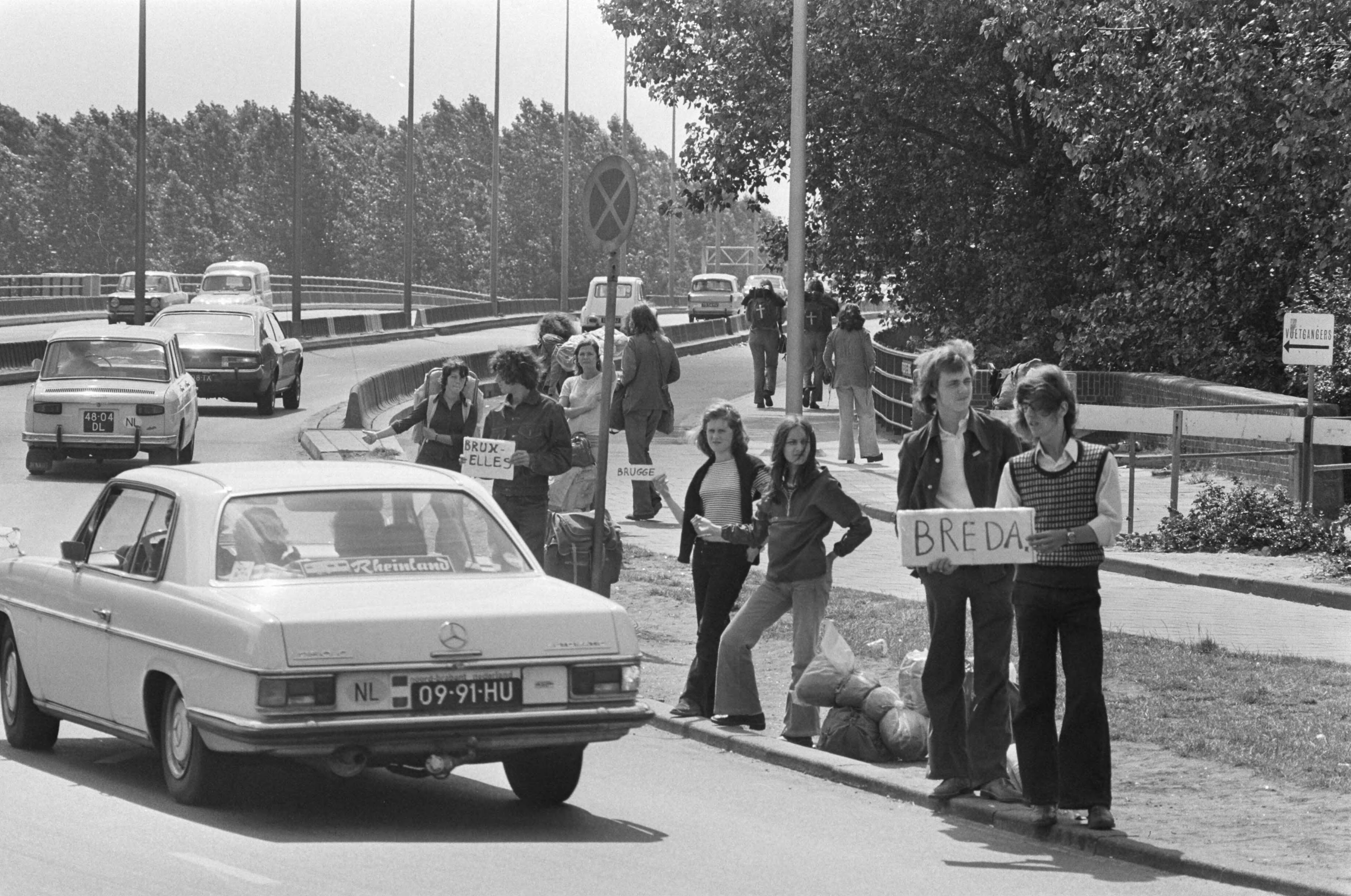 Fotocollectie Anefo — Vakantie uittocht begonnen; lange rij lifters bij Utrechtse brug — Foto: Verhoeff, Bert / Anefo. Licentie: Set B: Rechtenvrij / Publiek Domein. Bron: Nationaal Archief. http://hdl.handle.net/10648/ac502d28-d0b4-102d-bcf8-003048976d84