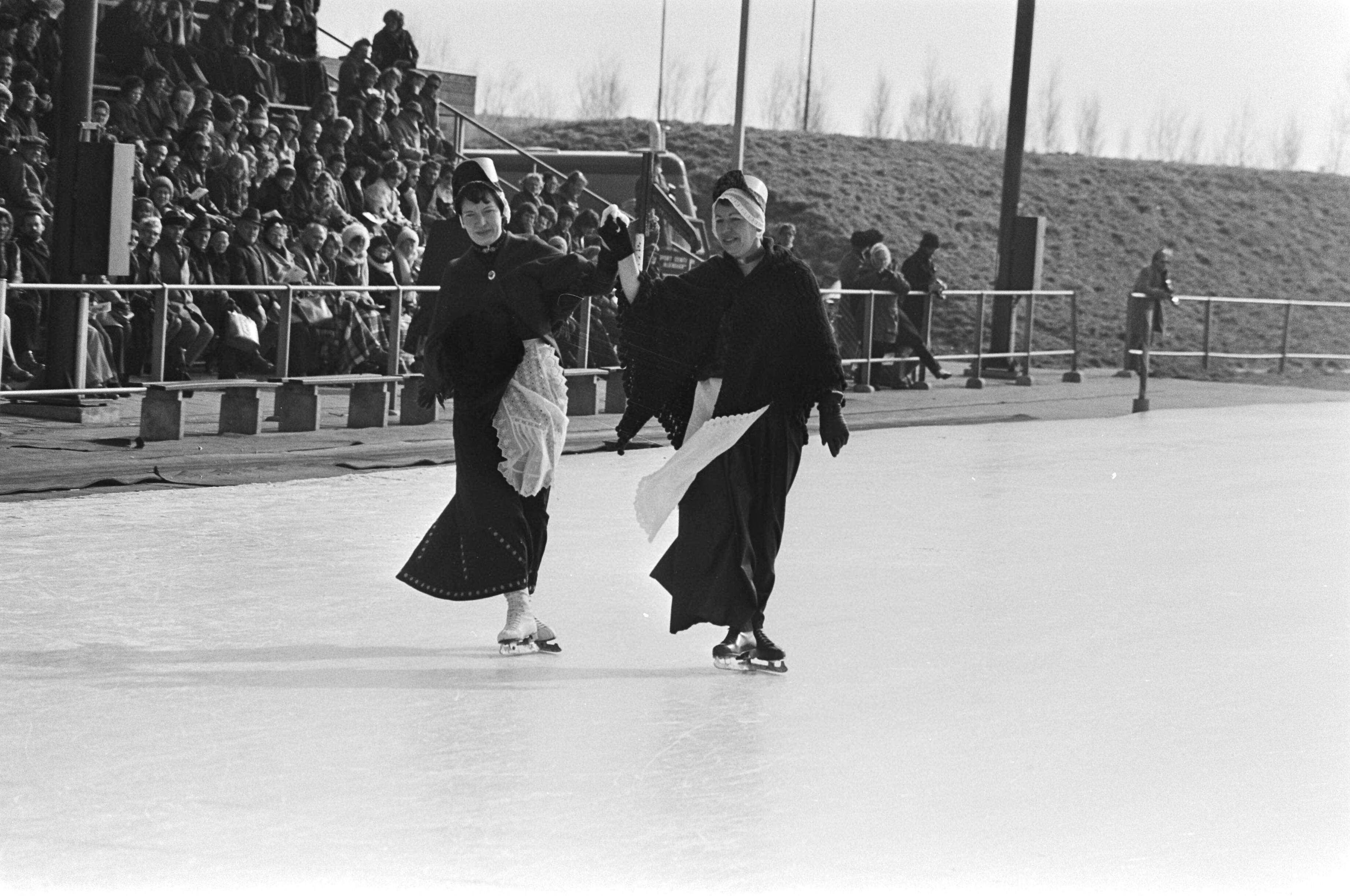 Fotocollectie Anefo — Oud-hollandse ijsfolklore op kunstijsbaan Alkmaar; schoonrijden in klederdracht — Foto: Bogaerts, Rob / Anefo. Licentie: Set B: Rechtenvrij / Publiek Domein. Bron: Nationaal Archief. http://hdl.handle.net/10648/ac7eaf54-d0b4-102d-bcf8-003048976d84