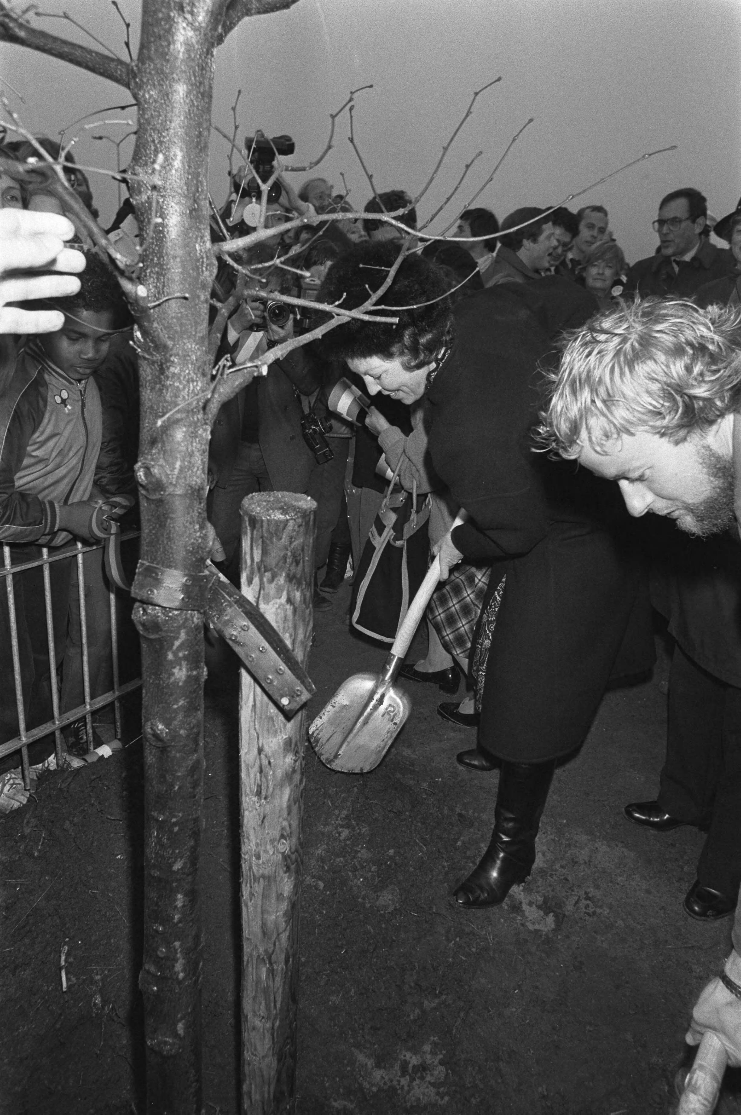 Koningin Beatrix bezoekt Almere in verband met het 5-jarig bestaan — Koningin Beatrix plant een boom in Almere — Foto: Croes, Rob C. / Anefo. Licentie: Set B: Rechtenvrij / Publiek Domein. Bron: Nationaal Archief. http://hdl.handle.net/10648/ad0a01b2-d0b4-102d-bcf8-003048976d84