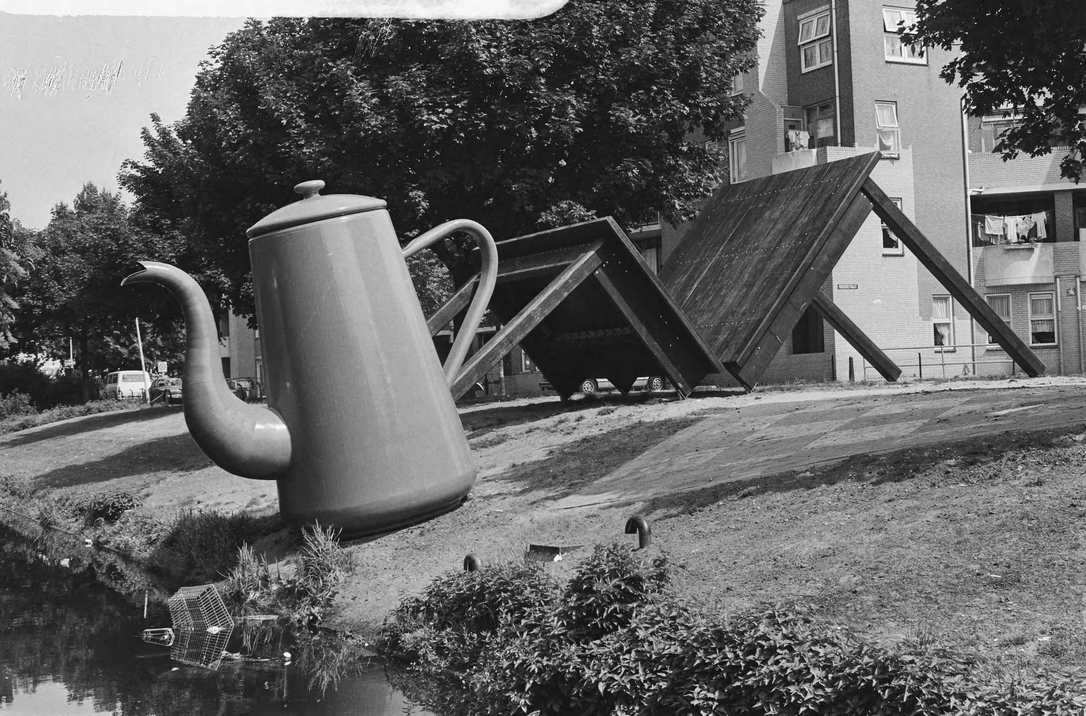 Fotocollectie Anefo — Kunstwerk, reusachtige ontbijttafel, koffiepot, twee betonnen boterhammem en gebroken tafel aan de Noordpolderkade in Den Haag — Foto: Gerrits, Roland / Anefo. Licentie: Set B: Rechtenvrij / Publiek Domein. Bron: Nationaal Archief. http://hdl.handle.net/10648/ad55138c-d0b4-102d-bcf8-003048976d84