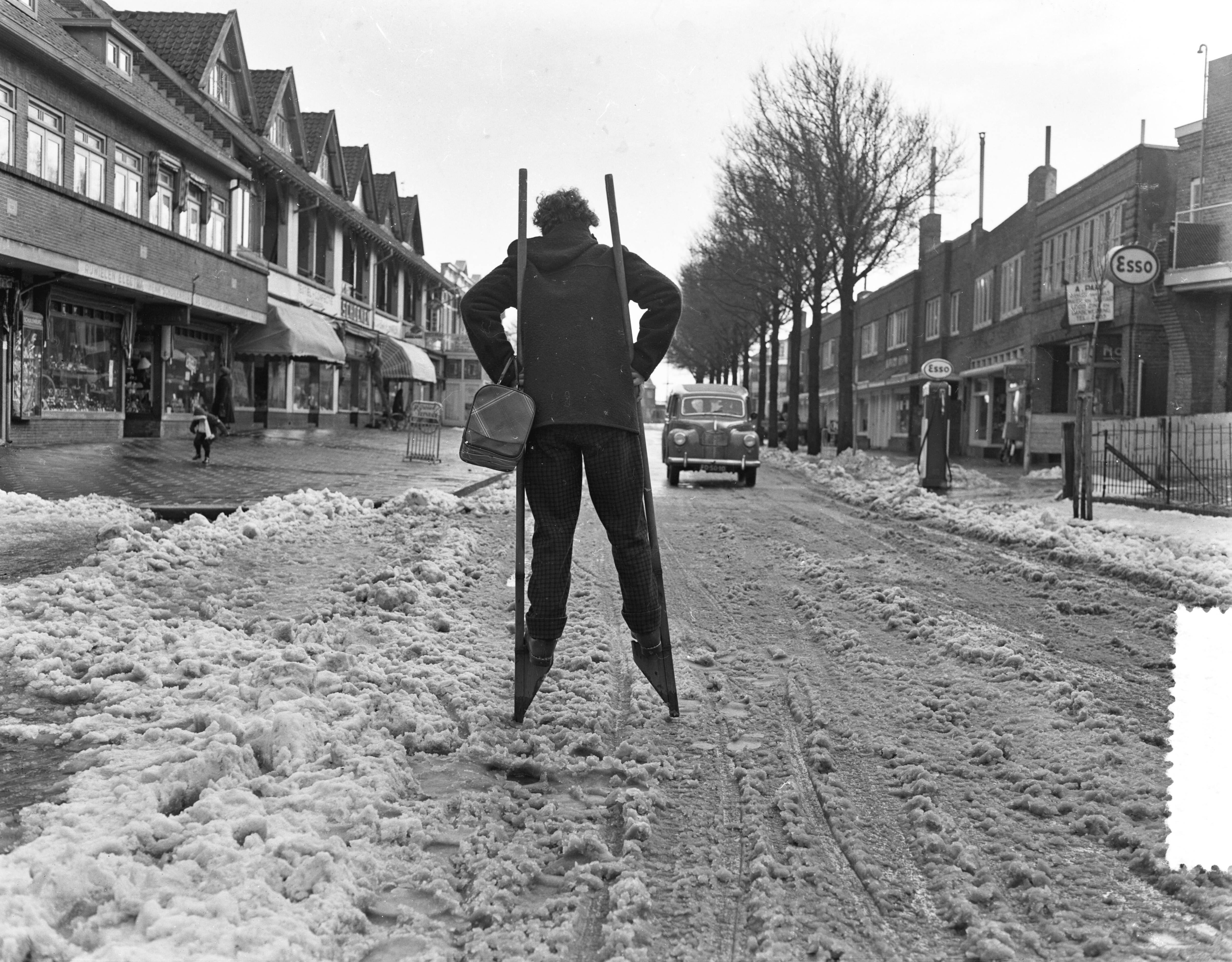 Fotocollectie Anefo — Meisje loopt op stelten over een besneeuwde straat [de Grote Krocht] te Zandvoort — Foto: Pot, Harry / Anefo. Licentie: Set B: Rechtenvrij / Publiek Domein. Bron: Nationaal Archief. http://hdl.handle.net/10648/a94168b8-d0b4-102d-bcf8-003048976d84