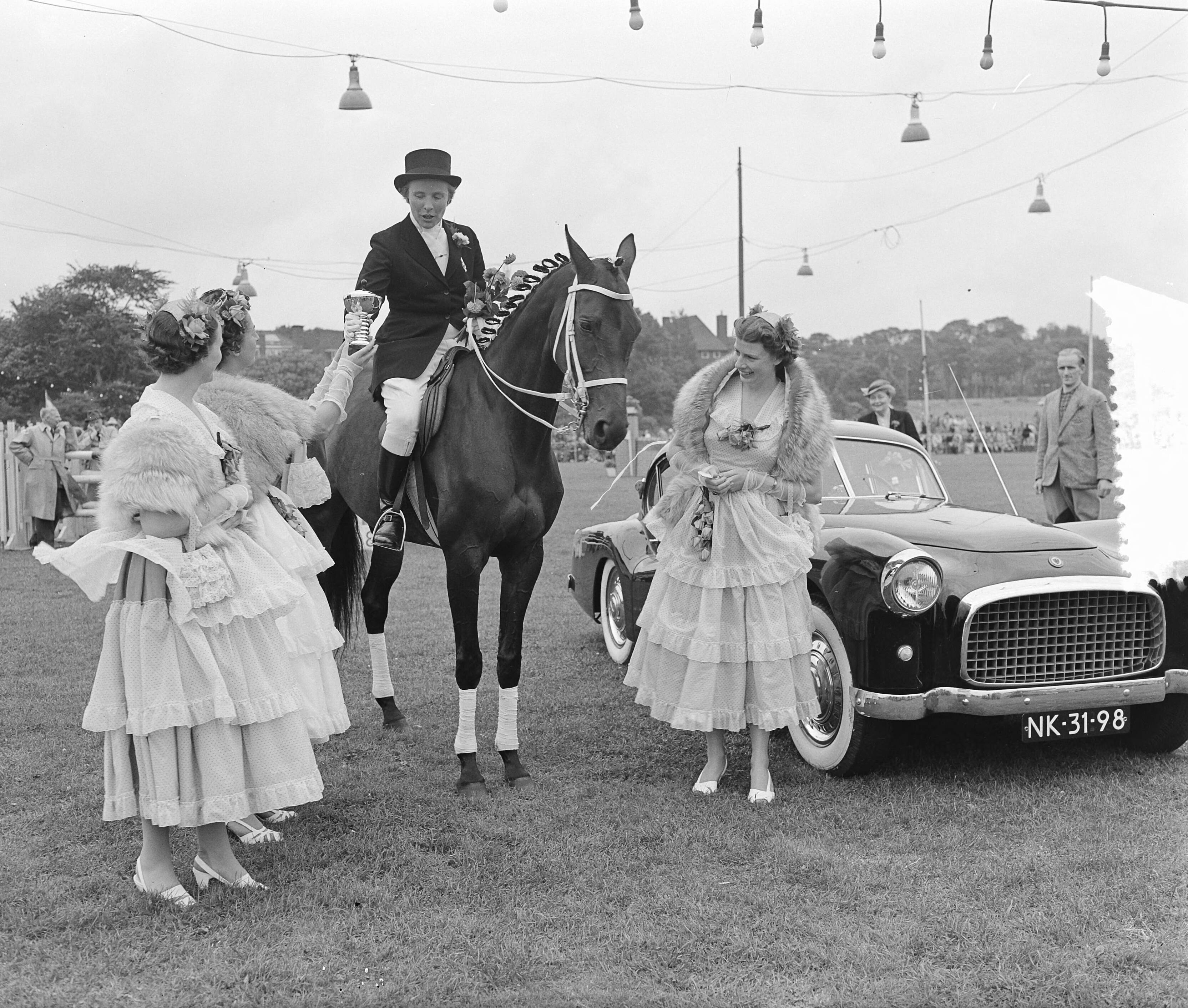 Fotocollectie Anefo — Concours Hippique Den Haag. Prijsuitreiking door de Haagse Bloemenkoningin Gusta van der Leuv — Foto: Rossem, Wim van / Anefo. Licentie: Set B: Rechtenvrij / Publiek Domein. Bron: Nationaal Archief. http://hdl.handle.net/10648/a927a0a4-d0b4-102d-bcf8-003048976d84