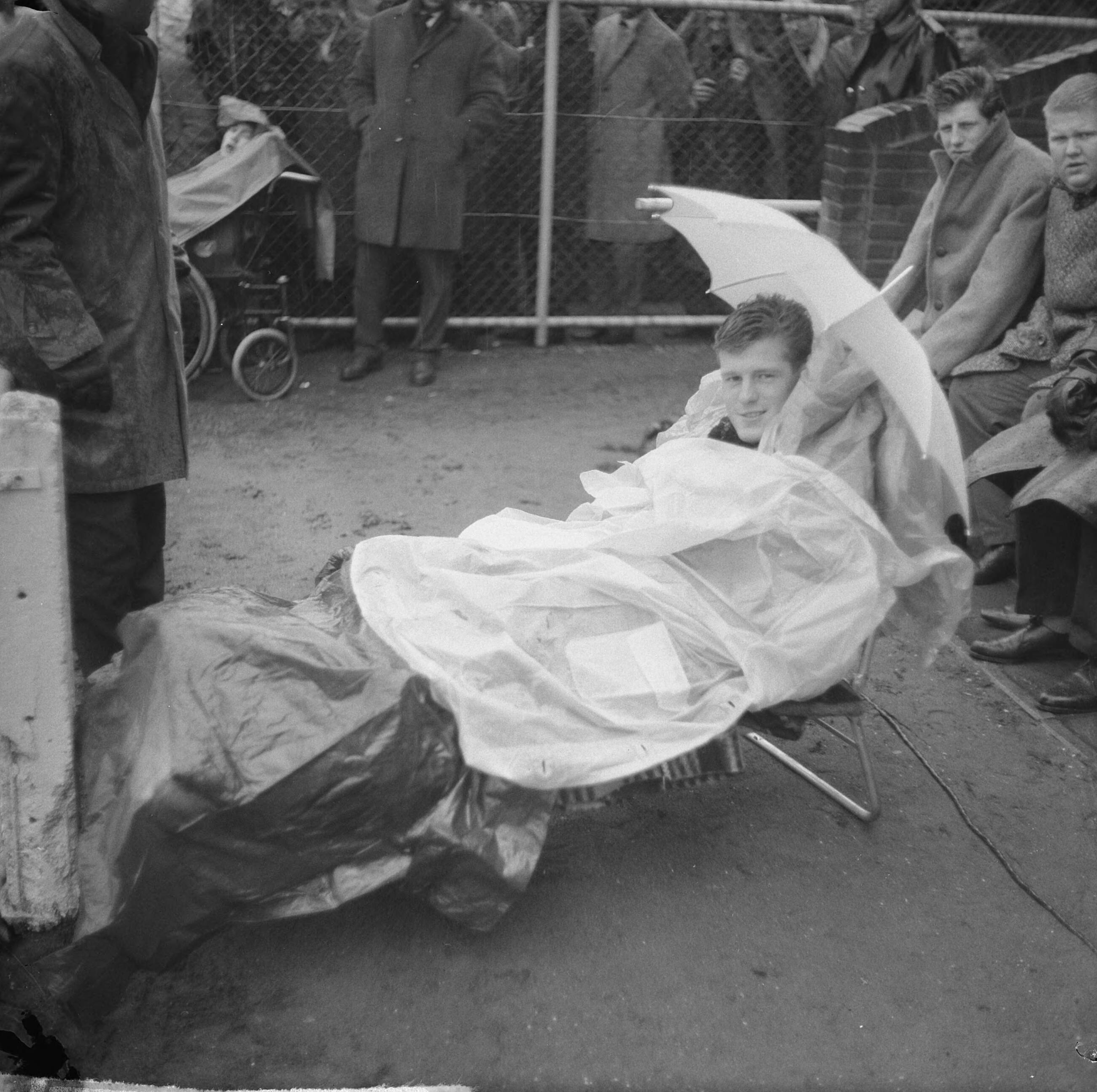 Fotocollectie Anefo — Voetbal. NAC tegen Feyenoord 1-0. Ati Graaumans speler NAC geblesseerd, zit op veldbed met paraplu en plastic jassen — Foto: Nijs, Jac. de / Anefo. Licentie: Set B: Rechtenvrij / Publiek Domein. Bron: Nationaal Archief. http://hdl.handle.net/10648/aa9a76be-d0b4-102d-bcf8-003048976d84