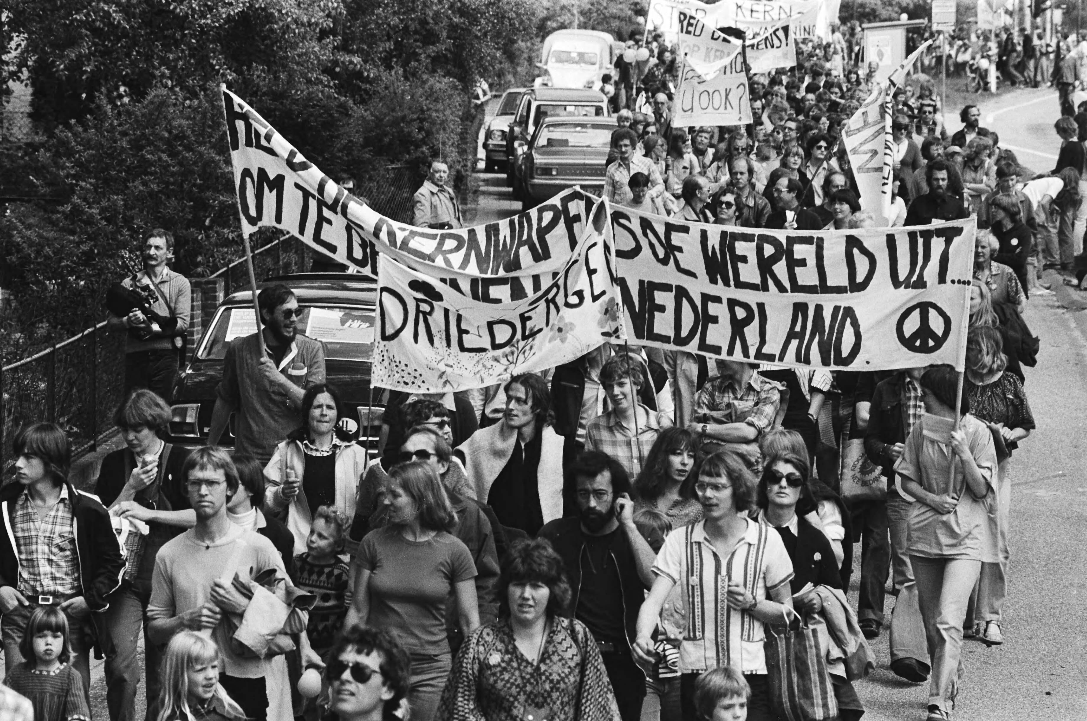 Demonstratie in Soesterberg tegen kernbewapening en opslag van kernwapens op vliegveld Soesterberg — Op de spandoeken staat o.a. "Alle kernwapens de wereld uit - om te beginnen uit Nederland" — Foto: Croes, Rob C. / Anefo. Licentie: Set B: Rechtenvrij / Publiek Domein. Bron: Nationaal Archief. http://hdl.handle.net/10648/acca74de-d0b4-102d-bcf8-003048976d84