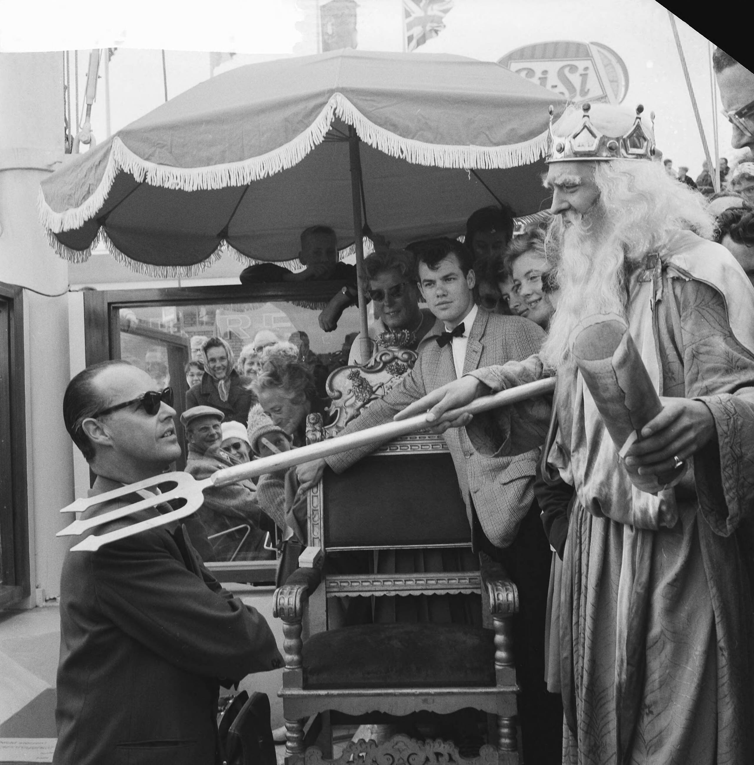 Fotocollectie Anefo — Miljoenste bezoeker op Scheveningse Pier. Neptunus slaat met zijn drietand de 39-jarige Rotterdamse zakenman R. Driebeek tot ridder in de Orde van de Zilveren Zeester — Foto: Lindeboom, Henk / Anefo. Licentie: Set B: Rechtenvrij / Publiek Domein. Bron: Nationaal Archief. http://hdl.handle.net/10648/a9dd2b72-d0b4-102d-bcf8-003048976d84