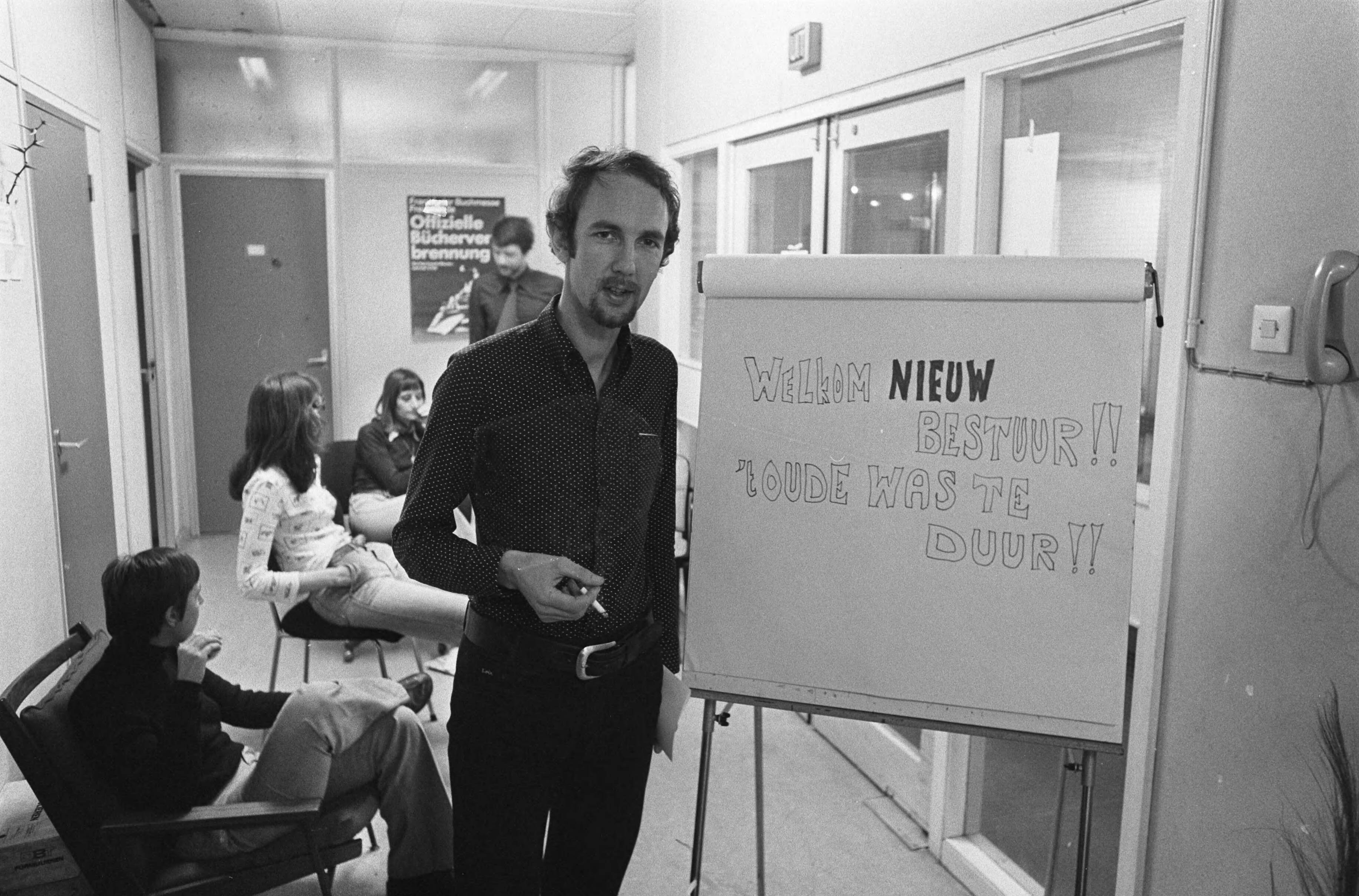 Fotocollectie Anefo — Hoofdkantoor NVSH bezet door aanhangers nieuw hoofdbestuur in Den Haag ; nieuwe voorzitter John Tiggelman naast een bord bij de hoofdingang / — Foto: Verhoeff, Bert / Anefo. Licentie: Set B: Rechtenvrij / Publiek Domein. Bron: Nationaal Archief. http://hdl.handle.net/10648/ac55ed94-d0b4-102d-bcf8-003048976d84