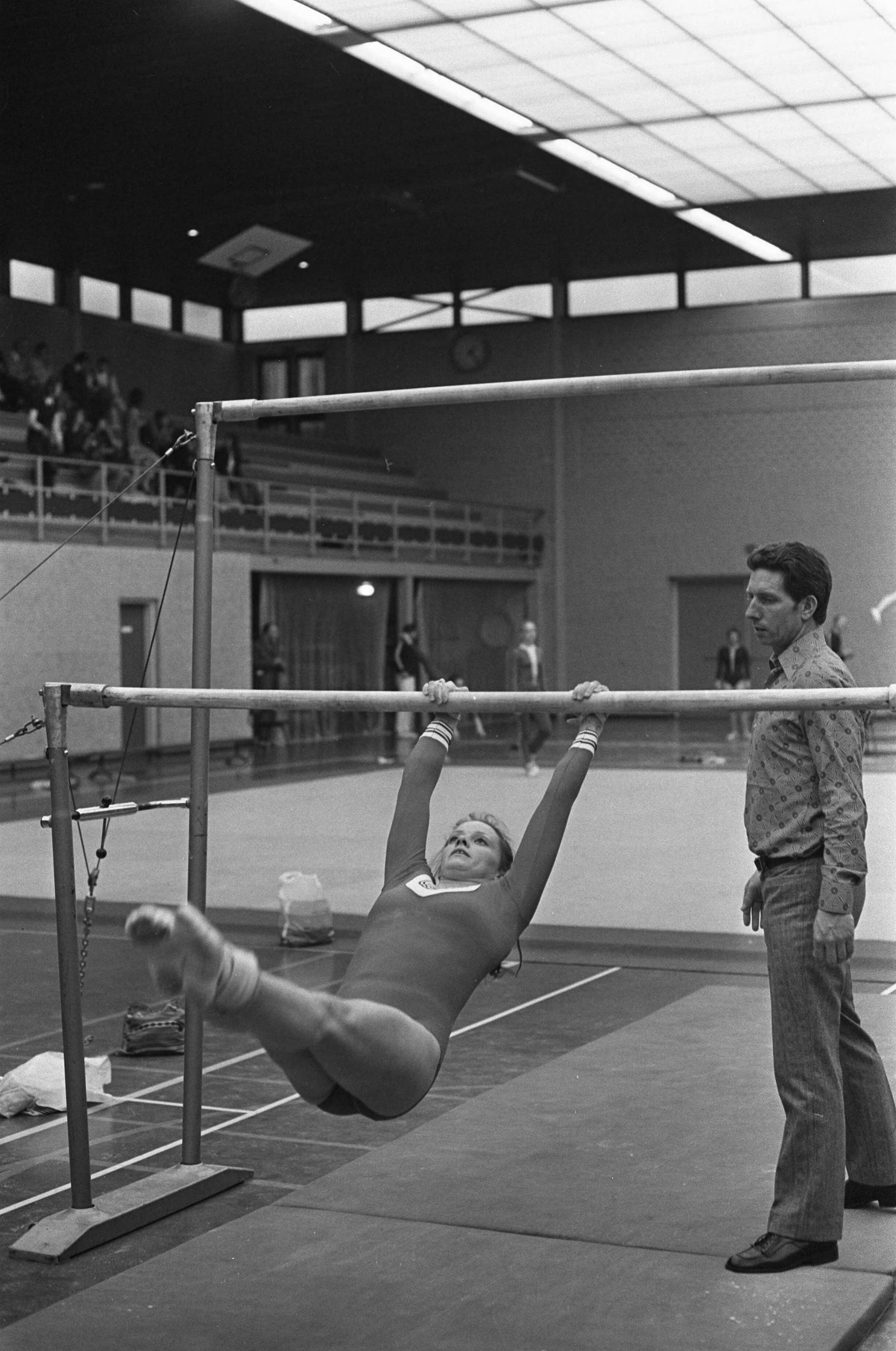 Nederlandse Turnkampioenschappen voor dames in Den Haag — Kampioene Ans van Gerwen in actie aan de ongelijke brug — Foto: Fotograaf Onbekend / Anefo. Licentie: Set B: Rechtenvrij / Publiek Domein. Bron: Nationaal Archief. http://hdl.handle.net/10648/abe7c0da-d0b4-102d-bcf8-003048976d84