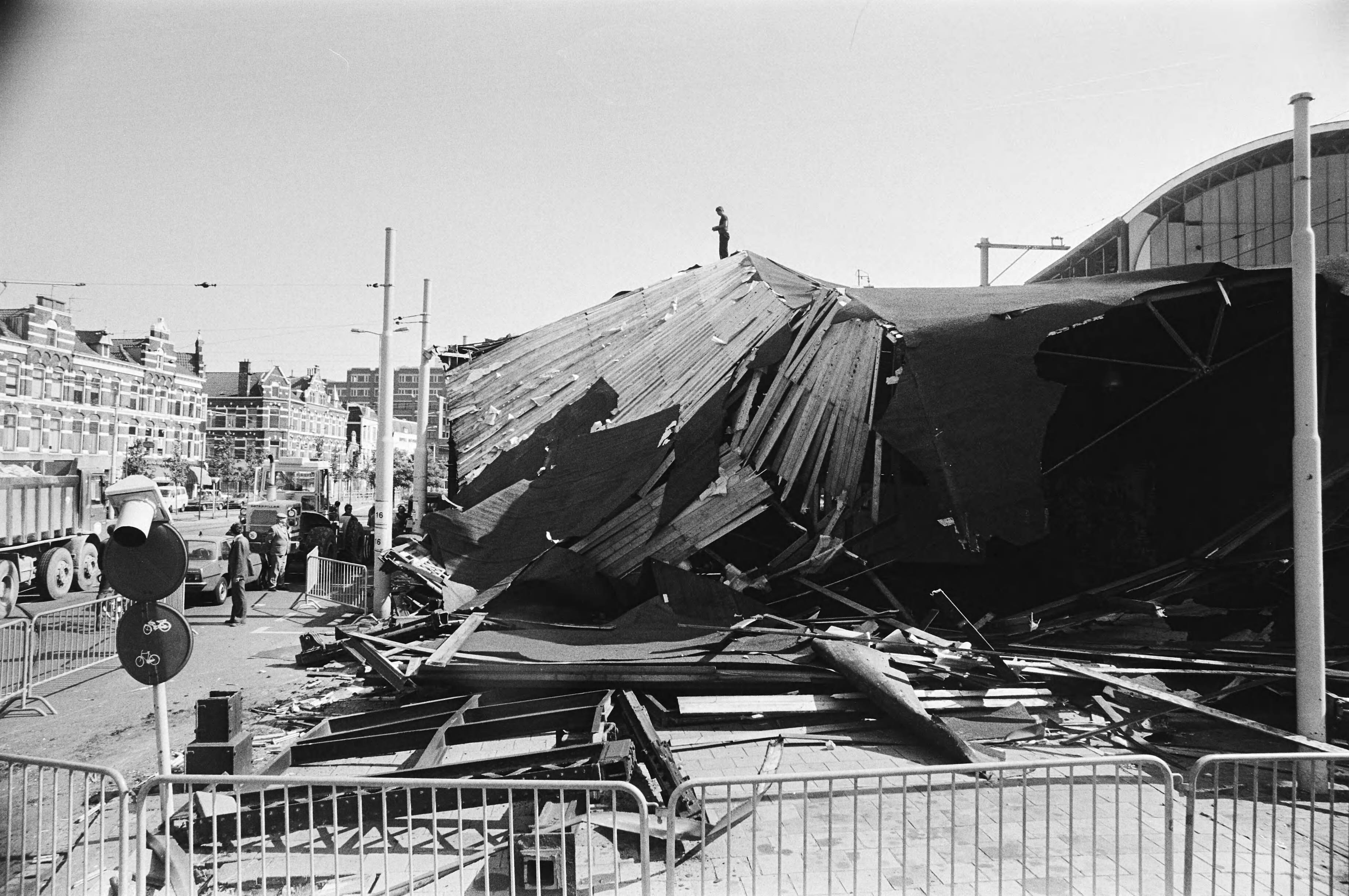 Ingestort gedeelte van de dakconstructie van station Hollands Spoor in Den Haag na de aanrijding door een vrachtauto — Den Haag|Zuid-Holland|stations |instortingen |verwoestingen|Hollands Spoor — Foto: Suyk, Koen / Anefo. Licentie: Set B: Rechtenvrij / Publiek Domein. Bron: Nationaal Archief. http://hdl.handle.net/10648/accf3b5e-d0b4-102d-bcf8-003048976d84