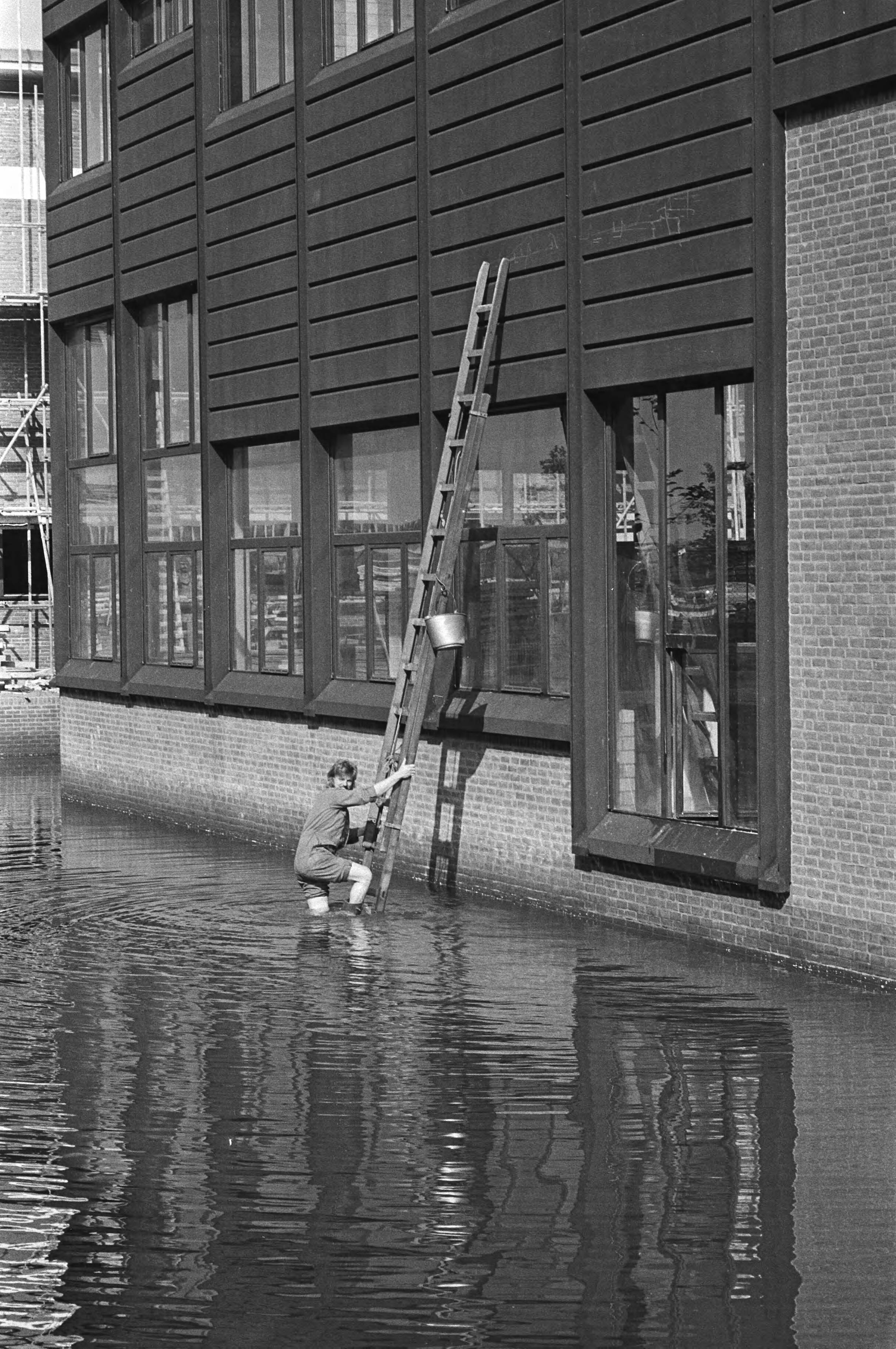 Glazenwasser met ladder in het water van het winkelcentrum in Almere Haven — Almere|Flevoland|glazenwassers |winkelcentra — Foto: Suyk, Koen / Anefo. Licentie: Set B: Rechtenvrij / Publiek Domein. Bron: Nationaal Archief. http://hdl.handle.net/10648/acd0a41c-d0b4-102d-bcf8-003048976d84