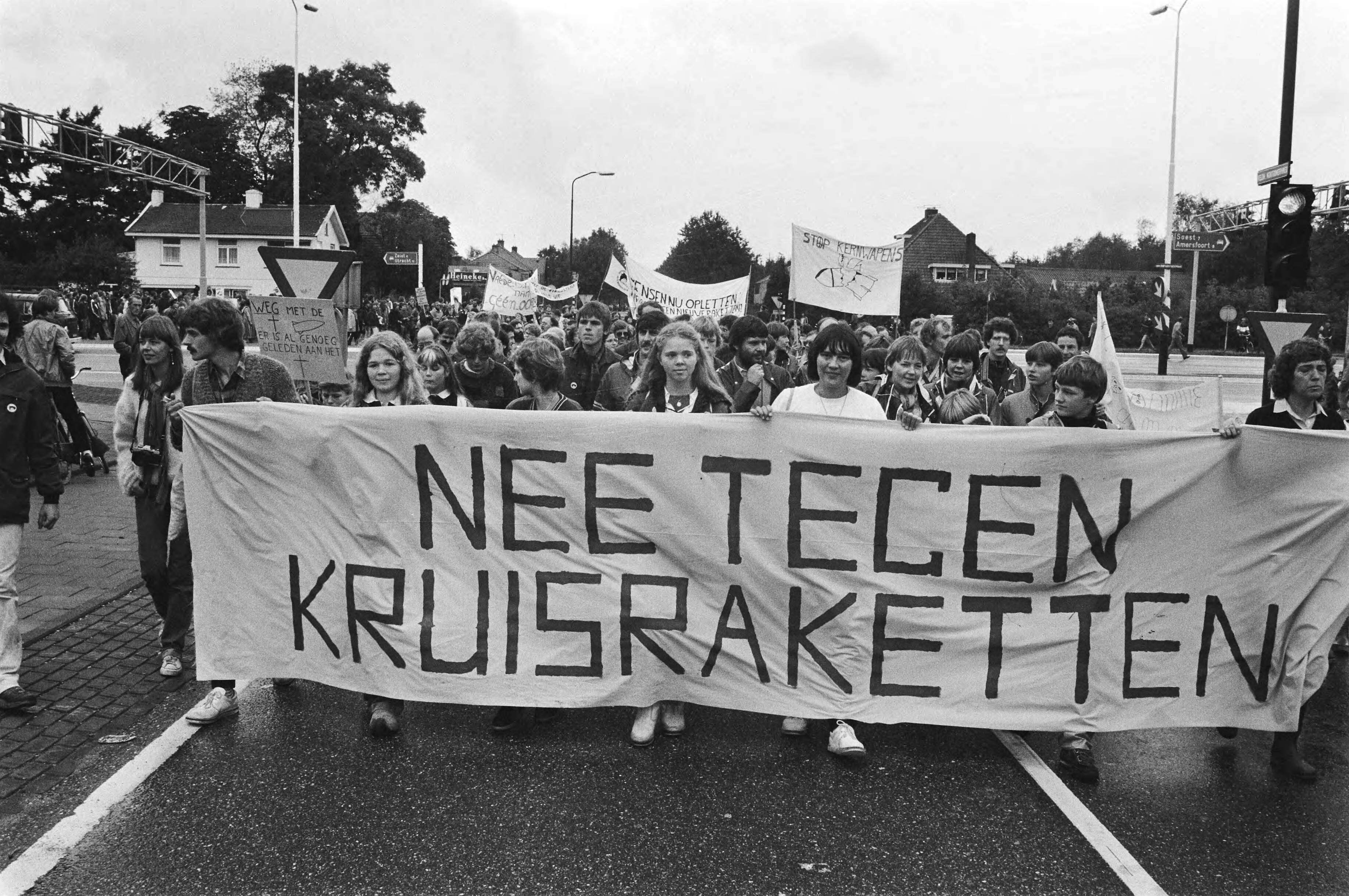 Jaarlijkse demonstratie tegen kernwapens in Soesterberg — Demonstranten achter een spandoek — Foto: Antonisse, Marcel / Anefo. Licentie: Set B: Rechtenvrij / Publiek Domein. Bron: Nationaal Archief. http://hdl.handle.net/10648/ad1fb62e-d0b4-102d-bcf8-003048976d84