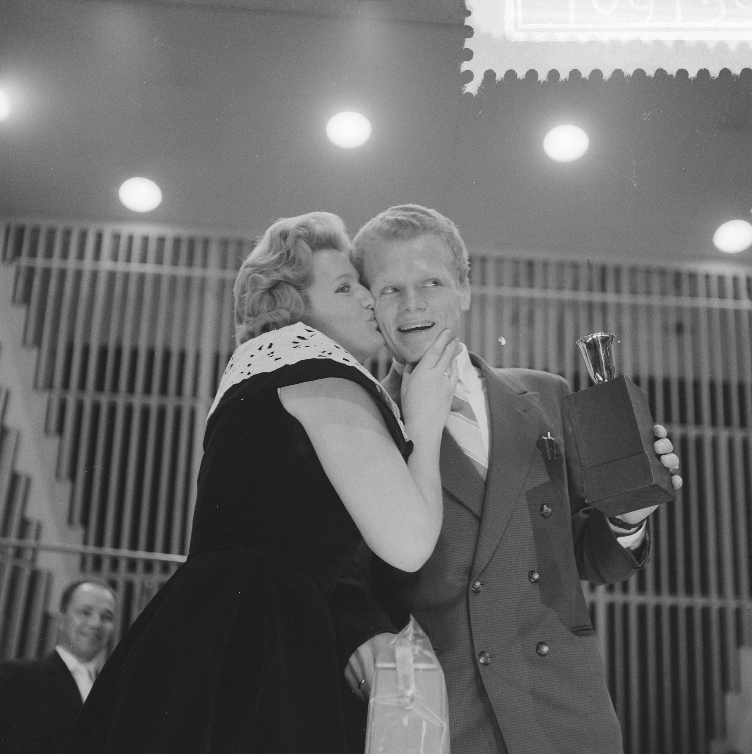 Fotocollectie Anefo — Verkiezing Sportman, Sportvrouw en Sportstad van het jaar. Wielrenner Arie van Houwelingen wordt gefeliciteerd door zangeres Mieke Telkamp — Foto: Lindeboom, Henk / Anefo. Licentie: Set B: Rechtenvrij / Publiek Domein. Bron: Nationaal Archief. http://hdl.handle.net/10648/a9a4e0aa-d0b4-102d-bcf8-003048976d84