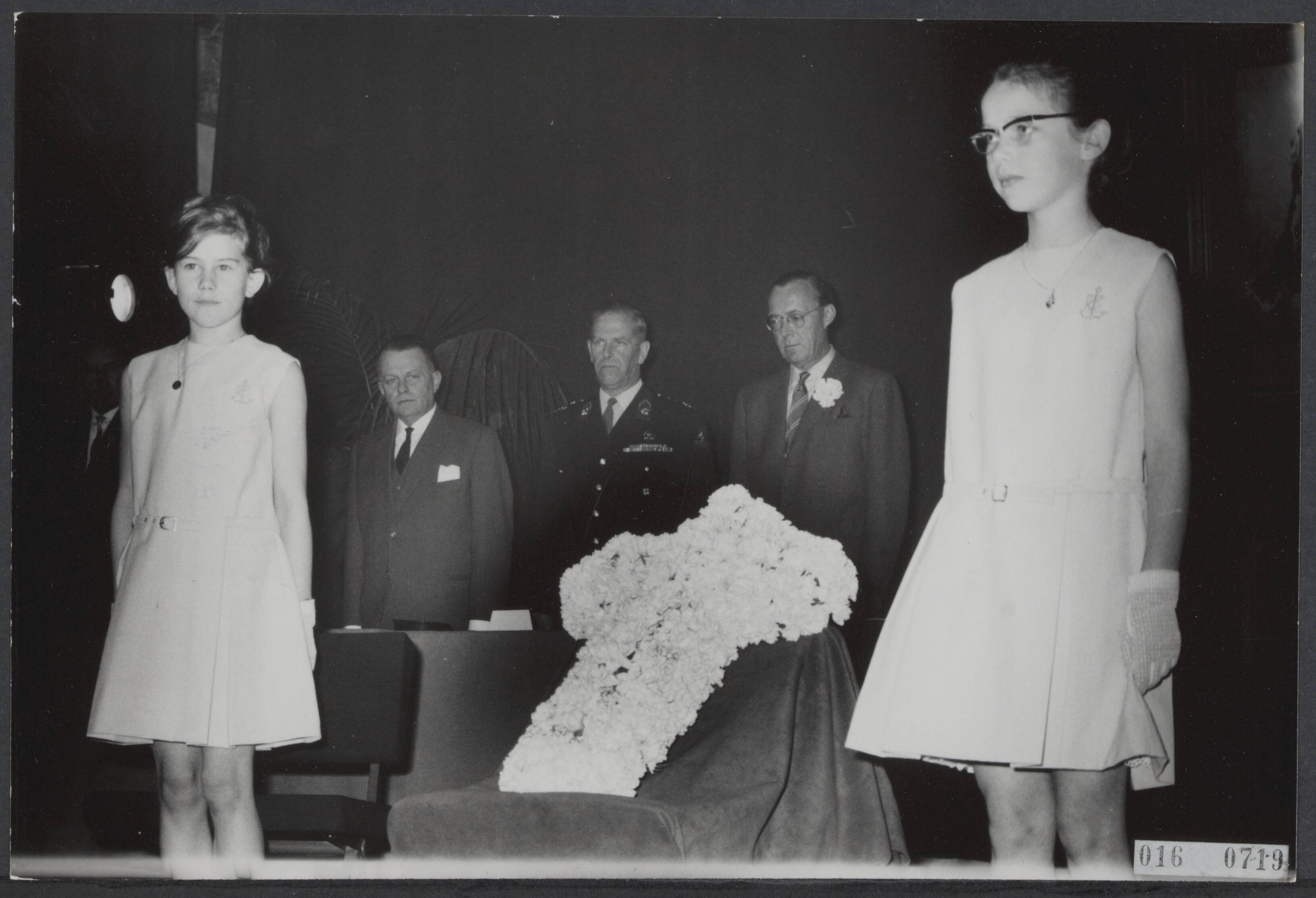 Fotocollectie Elsevier Binnenland — Prins Bernhard bracht een bezoek aan Breda waar hij aanwezig was bij de opening van het bevrijdingscongres Nationale Federatieve Raad van het voormalig Verzet Nederland in de aula van de K.M.A. Een bloemenkruis door twee meisjes voor de bestuurstafel gedragen was het symbool van dit congres. Op de achtergrond prins Bernhard en luitenant-generaal A.V. van den Wall Bake tijdens de inachtneming van een minuut stilte — Foto: Nijs, Jac. de / Anefo. Licentie: Set B: Rechtenvrij / Publiek Domein. Bron: Nationaal Archief. http://hdl.handle.net/10648/adba39f6-d0b4-102d-bcf8-003048976d84