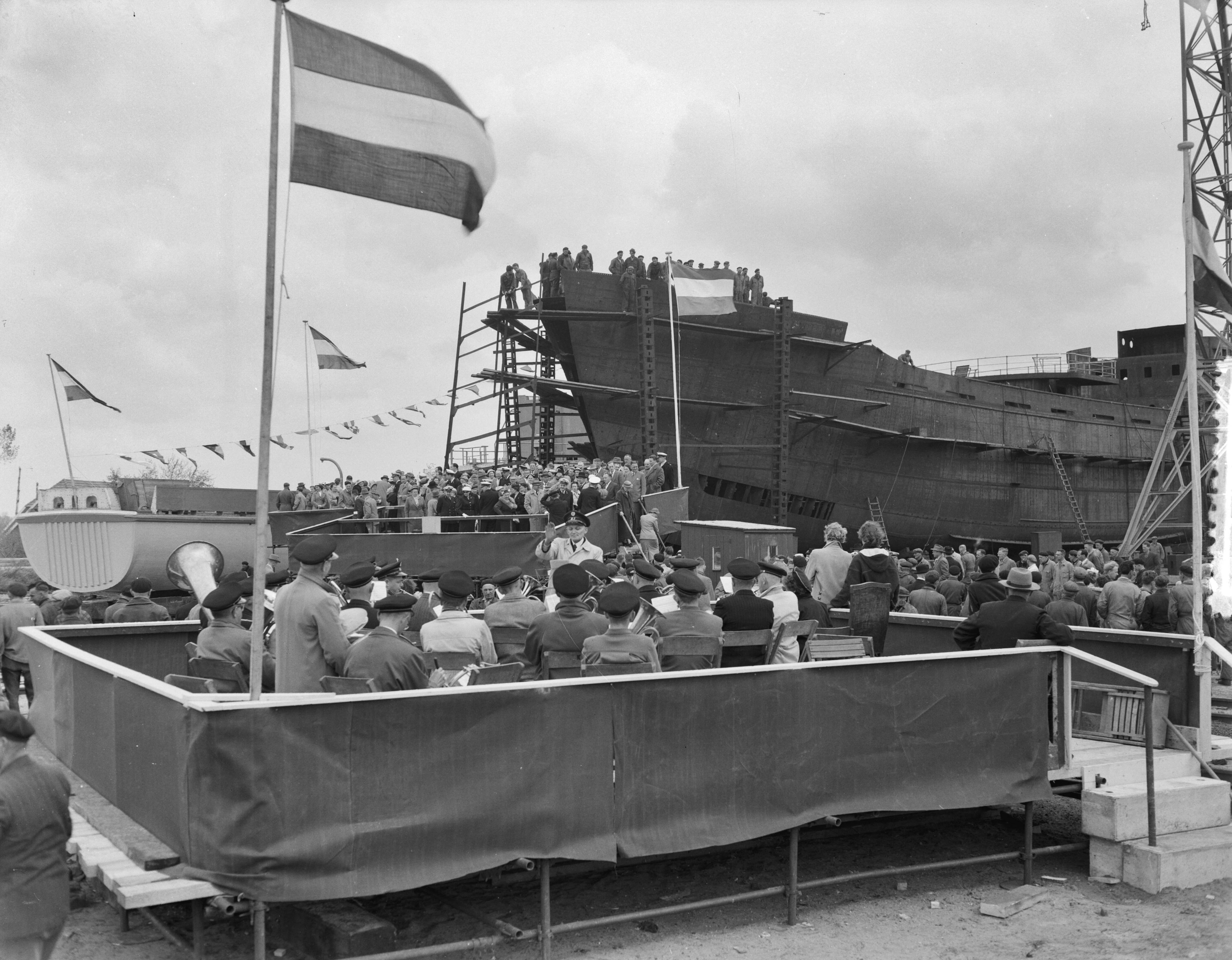 Fotocollectie Anefo — Tewaterlating van de mijnenveger Hr. Ms. "Lisse" bij scheepswerf E.J. Smit & Zn. te Westerbroek> Het muziekkorps uit Hoogezand-Sappemeer speelt het Wilhelmus — Foto: Rossem, Wim van / Anefo. Licentie: Set B: Rechtenvrij / Publiek Domein. Bron: Nationaal Archief. http://hdl.handle.net/10648/a9483fd0-d0b4-102d-bcf8-003048976d84