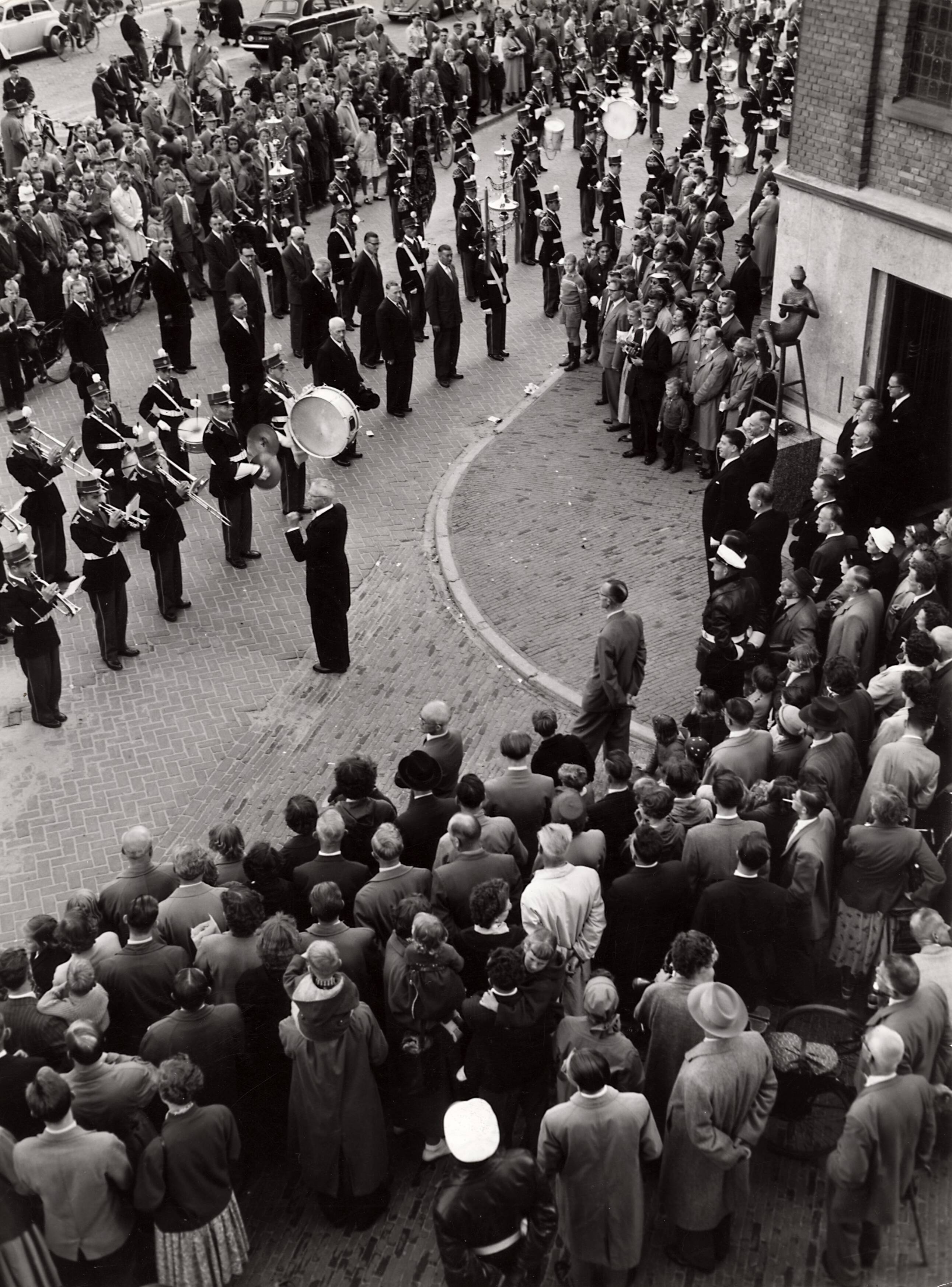 Collectie nader te bepalen — [50-jarig jubileum N.V. De Spaarnestad] [onthulling van de beelden van Hans Petri bij de hoofdingang van het Spaarnestadgebouw aan de Nassaulaan te Haarlem] [een muziekkorps speelt] — Foto: Fotograaf Onbekend / Fotobureau onbekend / Spaarnestad Photo (05887). Licentie: Set B: Rechtenvrij / Publiek Domein. Bron: Nationaal Archief. http://hdl.handle.net/10648/35429da6-3a87-a382-e063-6df0900a6686