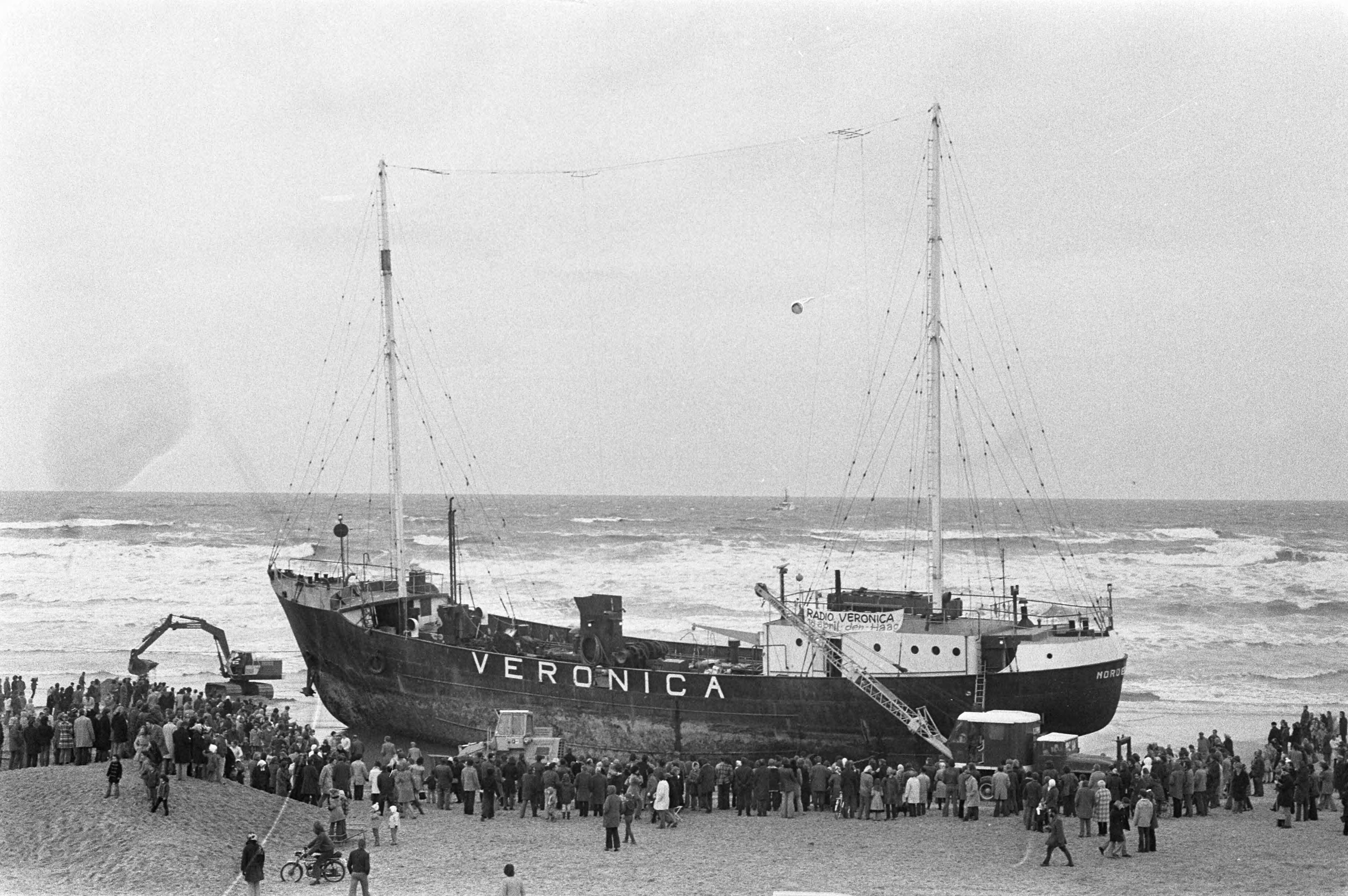 Fotocollectie Anefo — Werkzaamheden bij gestrande radio-zendschip Veronica op strand bij Scheveningen — Foto: Peters, Hans / Anefo. Licentie: Set B: Rechtenvrij / Publiek Domein. Bron: Nationaal Archief. http://hdl.handle.net/10648/ac28fd84-d0b4-102d-bcf8-003048976d84