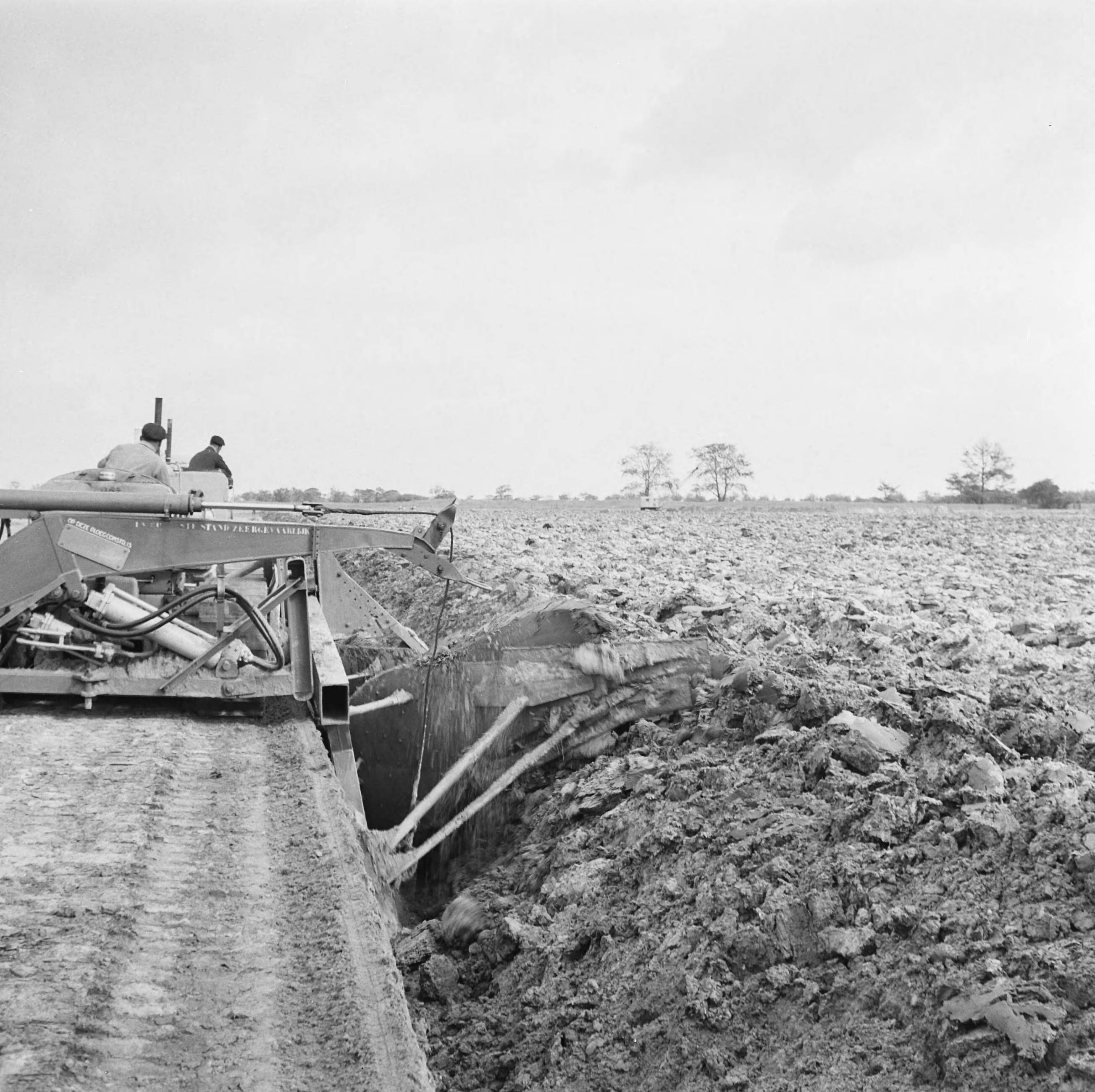 Fotocollectie Nederlandse Heidemaatschappij — Diepploegen acter de duinstrook (Vrouwenpolders - Walcheren). Achteraanzicht diepploeg — Foto: Fotograaf Onbekend / Heidemij. Licentie: Set B: Rechtenvrij / Publiek Domein. Bron: Nationaal Archief. http://hdl.handle.net/10648/ae5d6590-d0b4-102d-bcf8-003048976d84