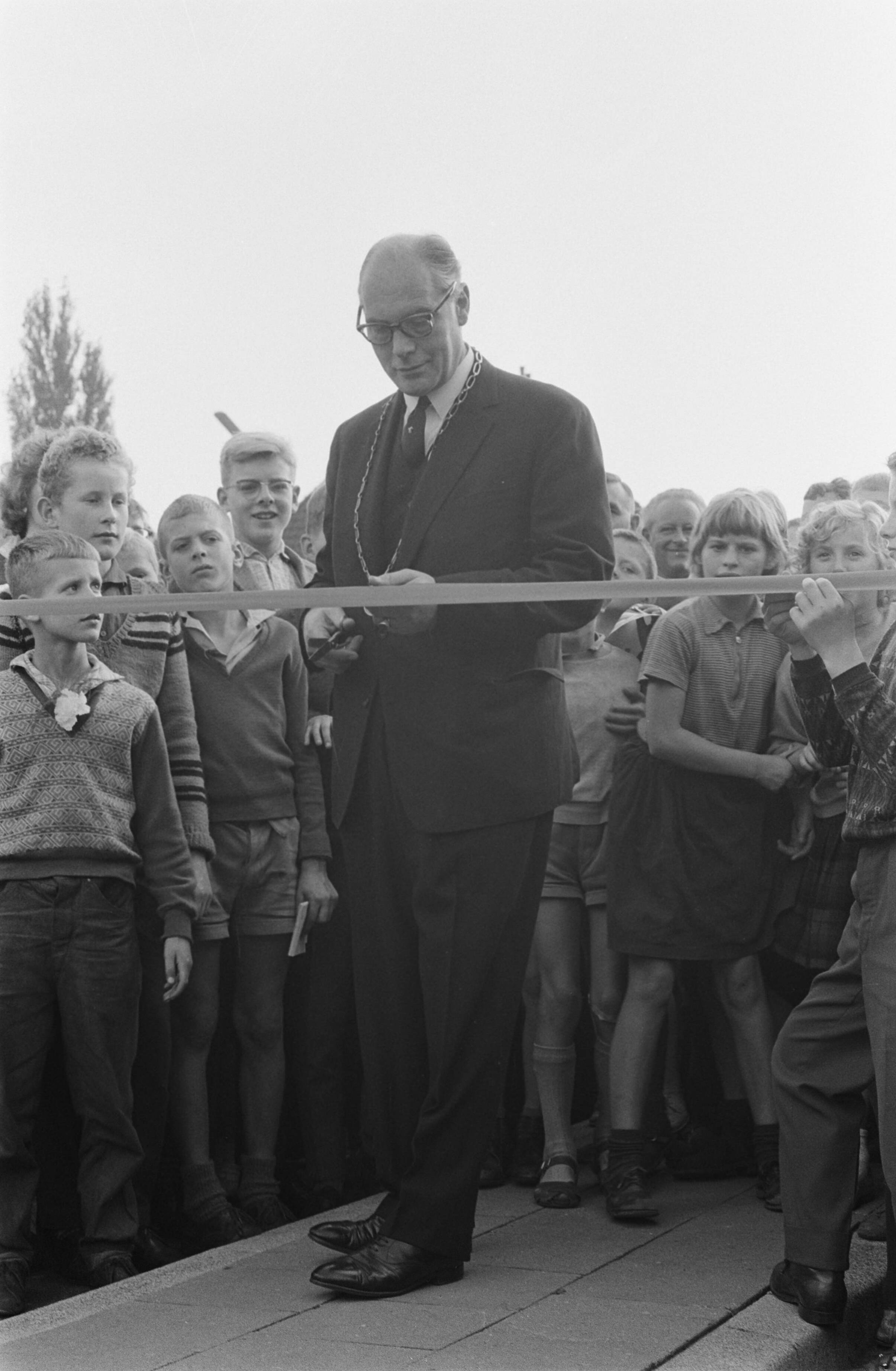 Fotocollectie Anefo — Hessenweg in De Bilt geopend door burgemeester K. Fabius. De burgemeester knipt een lint door — Foto: Gelderen, Hugo van / Anefo. Licentie: Set B: Rechtenvrij / Publiek Domein. Bron: Nationaal Archief. http://hdl.handle.net/10648/aa1a3f6c-d0b4-102d-bcf8-003048976d84