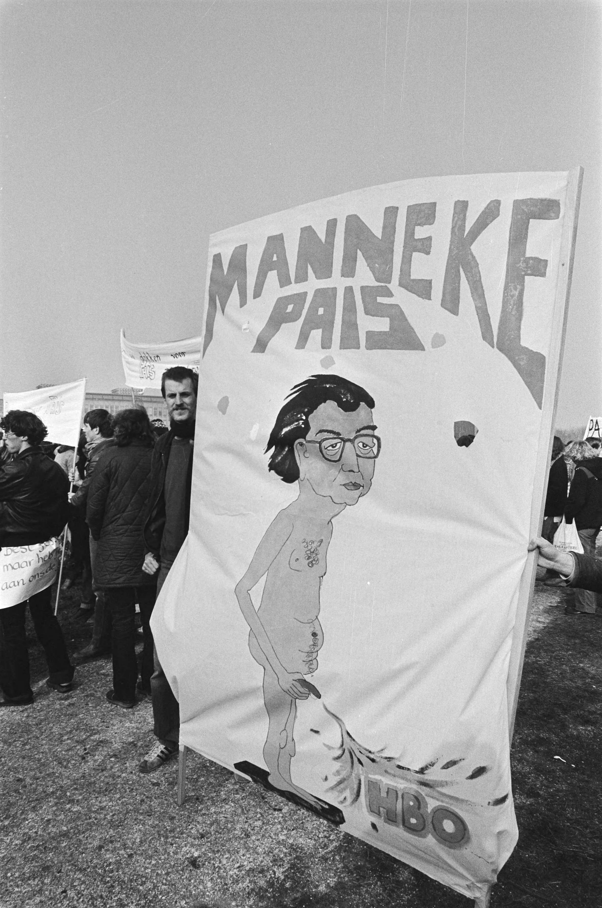 Fotocollectie Anefo — Demonstratie door 10.000 studenten in Den Haag tegen beleid Minister Pais (onderwijs), spandoek met Minister Pais als Manneke Pais — Foto: Dijk, Hans van / Anefo. Licentie: Set B: Rechtenvrij / Publiek Domein. Bron: Nationaal Archief. http://hdl.handle.net/10648/acf58e30-d0b4-102d-bcf8-003048976d84