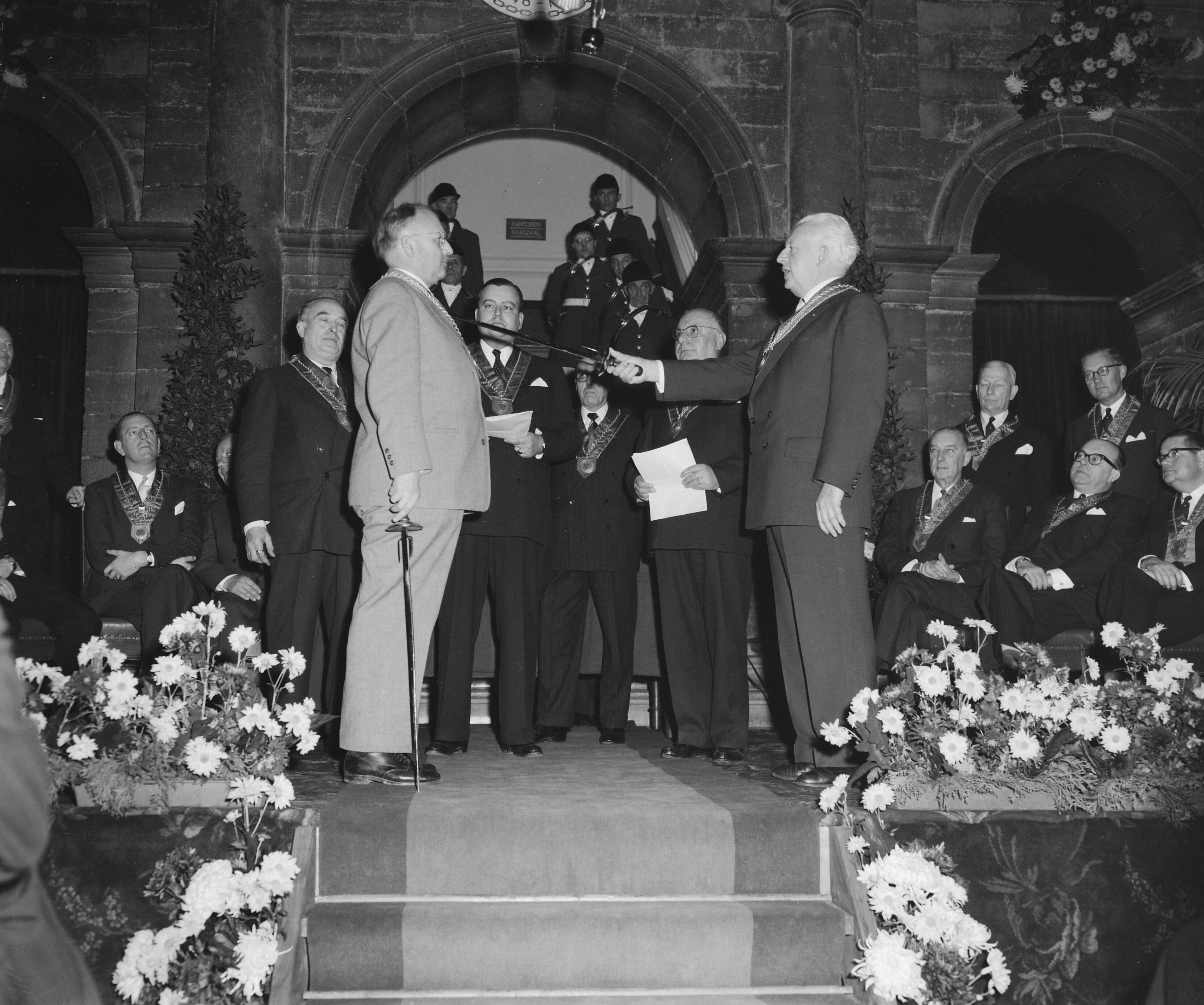 Fotocollectie Anefo — Installatie nieuwe leden van Confrerie de la Chaine des Rotisseurs in de hal van het stadhuis te Maastricht — Foto: Behrens, Herbert F. / Anefo. Licentie: Set B: Rechtenvrij / Publiek Domein. Bron: Nationaal Archief. http://hdl.handle.net/10648/a96ed2a8-d0b4-102d-bcf8-003048976d84