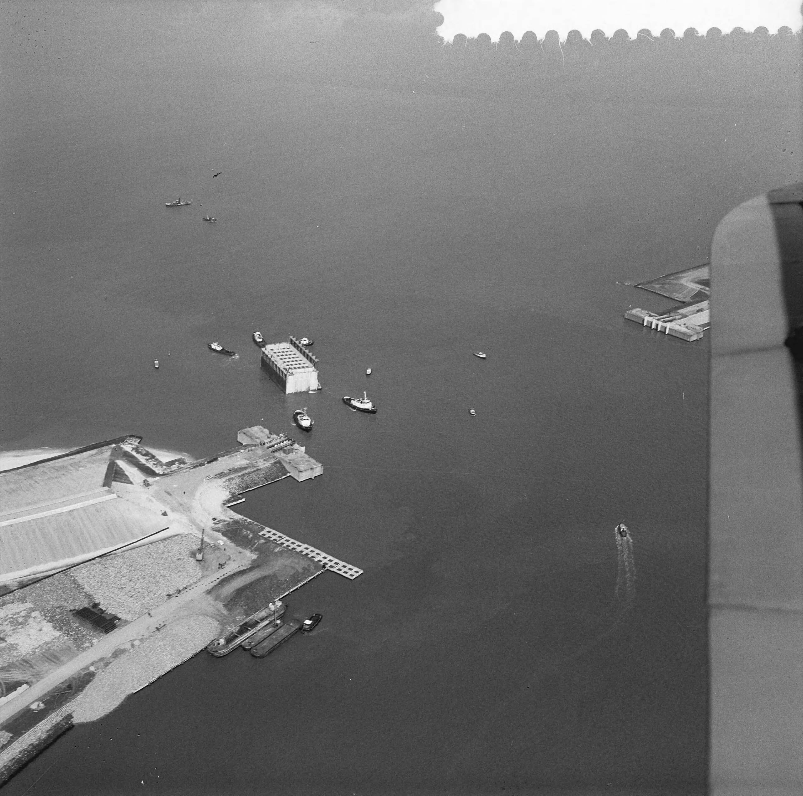 Fotocollectie Anefo — Luchtopnamen. Invaren van caissons in het Veerse Gat — Foto: Slagboom, Anton / Anefo. Licentie: Set B: Rechtenvrij / Publiek Domein. Bron: Nationaal Archief. http://hdl.handle.net/10648/a9d10d2e-d0b4-102d-bcf8-003048976d84