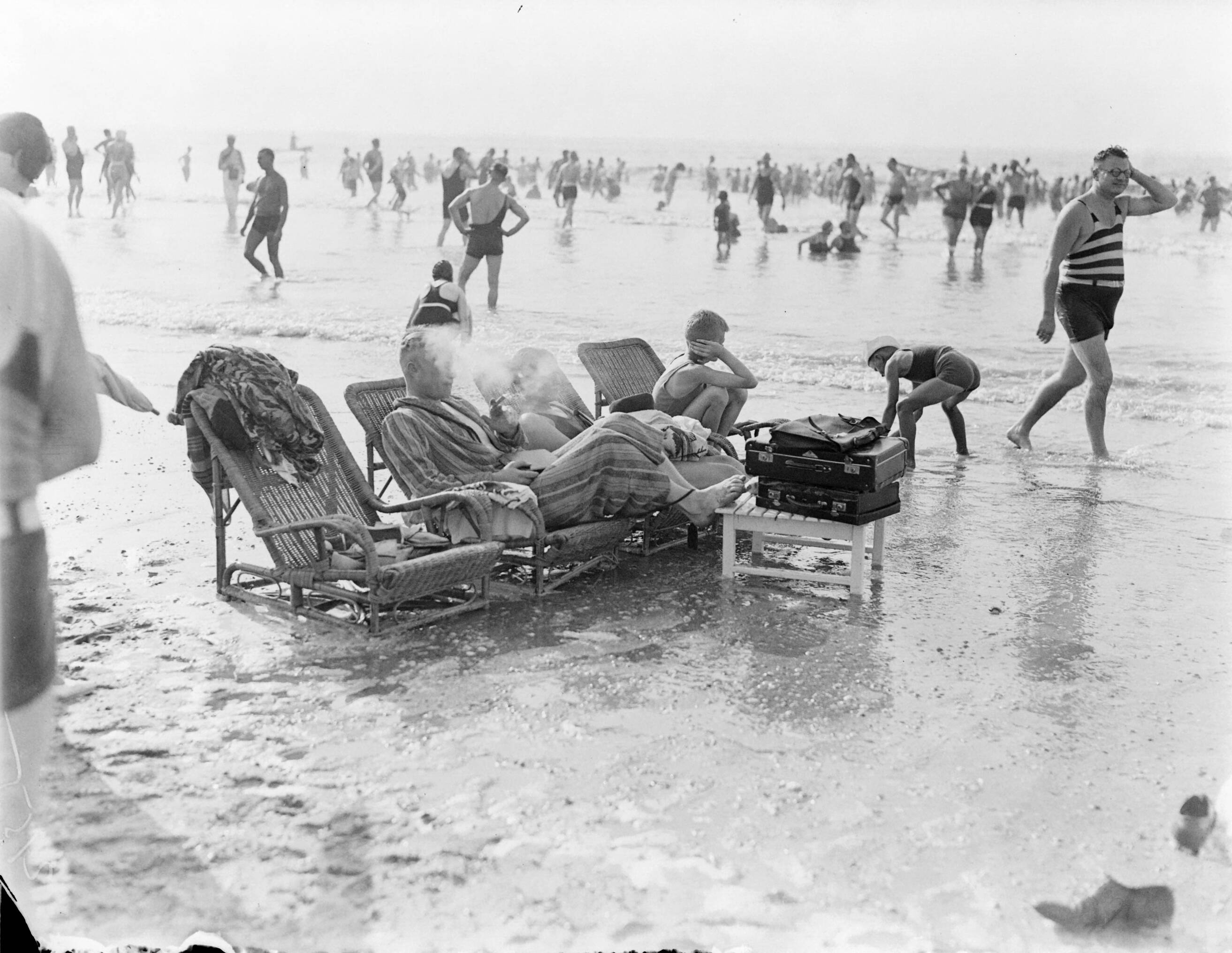 Strandtaferelen Scheveningen — Badgasten zittend op rieten ligstoelen in zee — Foto: Poll, Willem van de. Licentie: Set B: Rechtenvrij / Publiek Domein. Bron: Nationaal Archief. http://hdl.handle.net/10648/aea862e8-d0b4-102d-bcf8-003048976d84