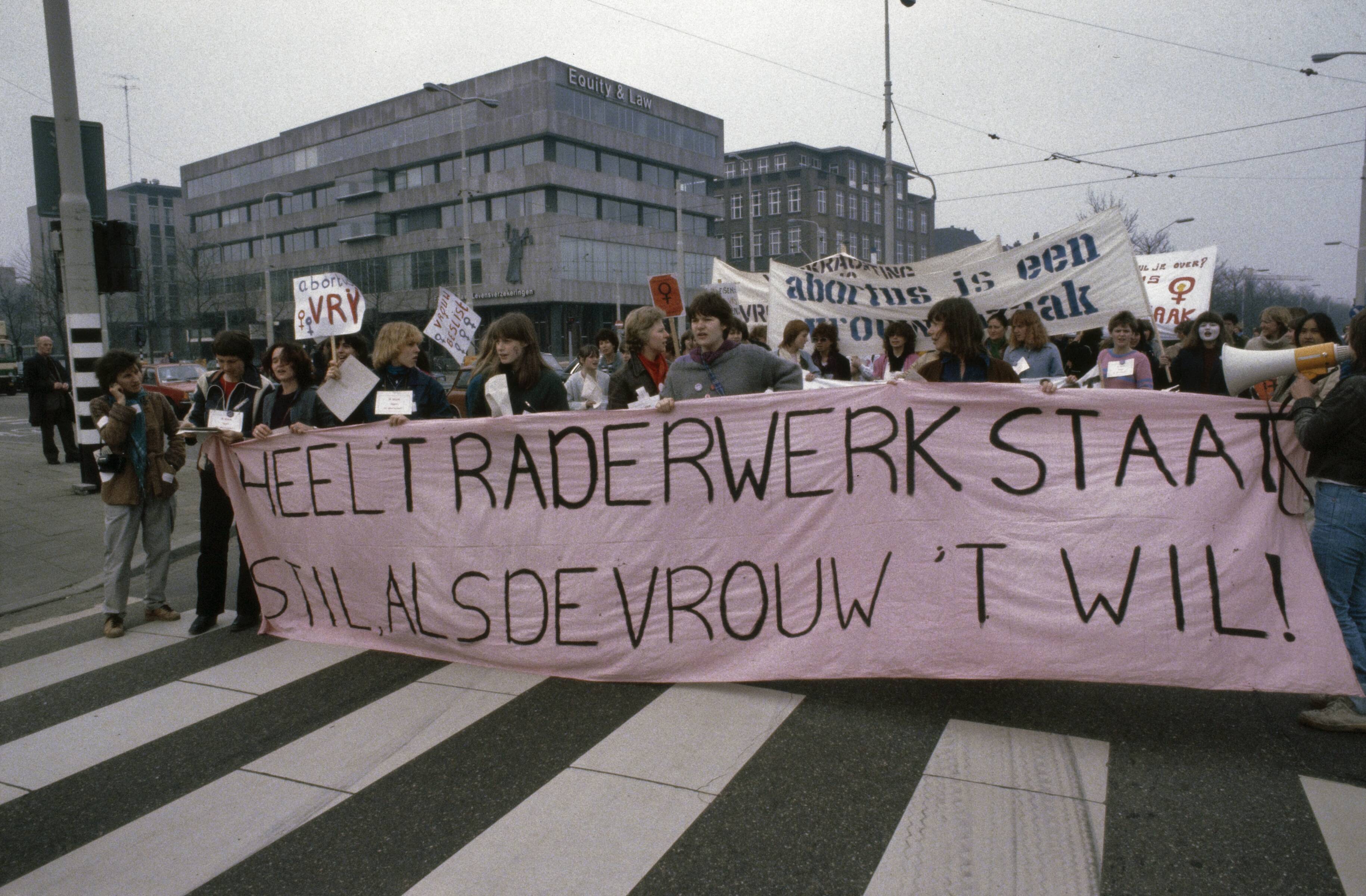 Fotocollectie Anefo — Landelijke vrouwenstakingsdag ( Den Haag ); demonstratie met borden en spandoeken onderweg in Den Haag — Foto: Dijk, Hans van / Anefo. Licentie: Set B: Rechtenvrij / Publiek Domein. Bron: Nationaal Archief. http://hdl.handle.net/10648/ad8a64ba-d0b4-102d-bcf8-003048976d84