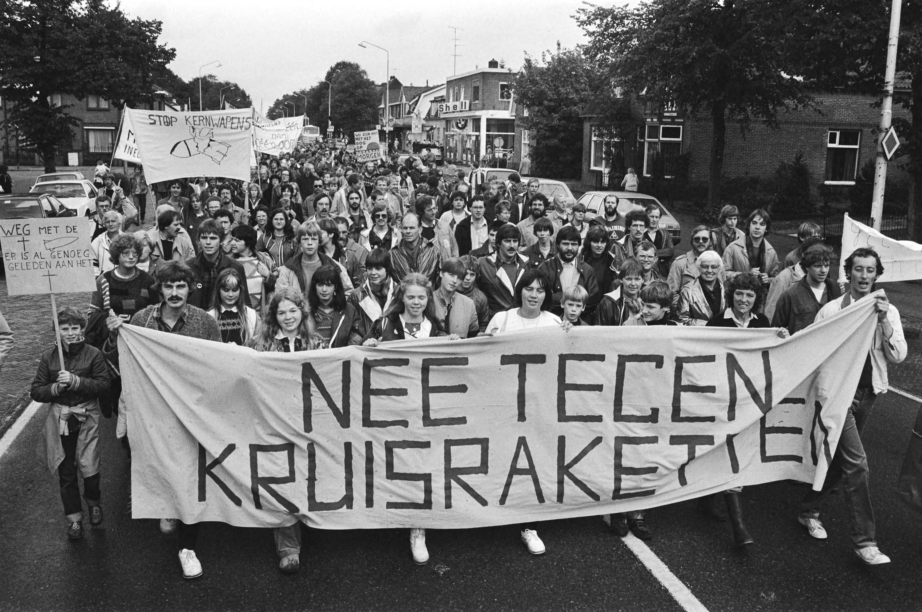 Jaarlijkse demonstratie tegen kernwapens in Soesterberg — Demonstranten achter een spandoek — Foto: Antonisse, Marcel / Anefo. Licentie: Set B: Rechtenvrij / Publiek Domein. Bron: Nationaal Archief. http://hdl.handle.net/10648/ad1fb502-d0b4-102d-bcf8-003048976d84