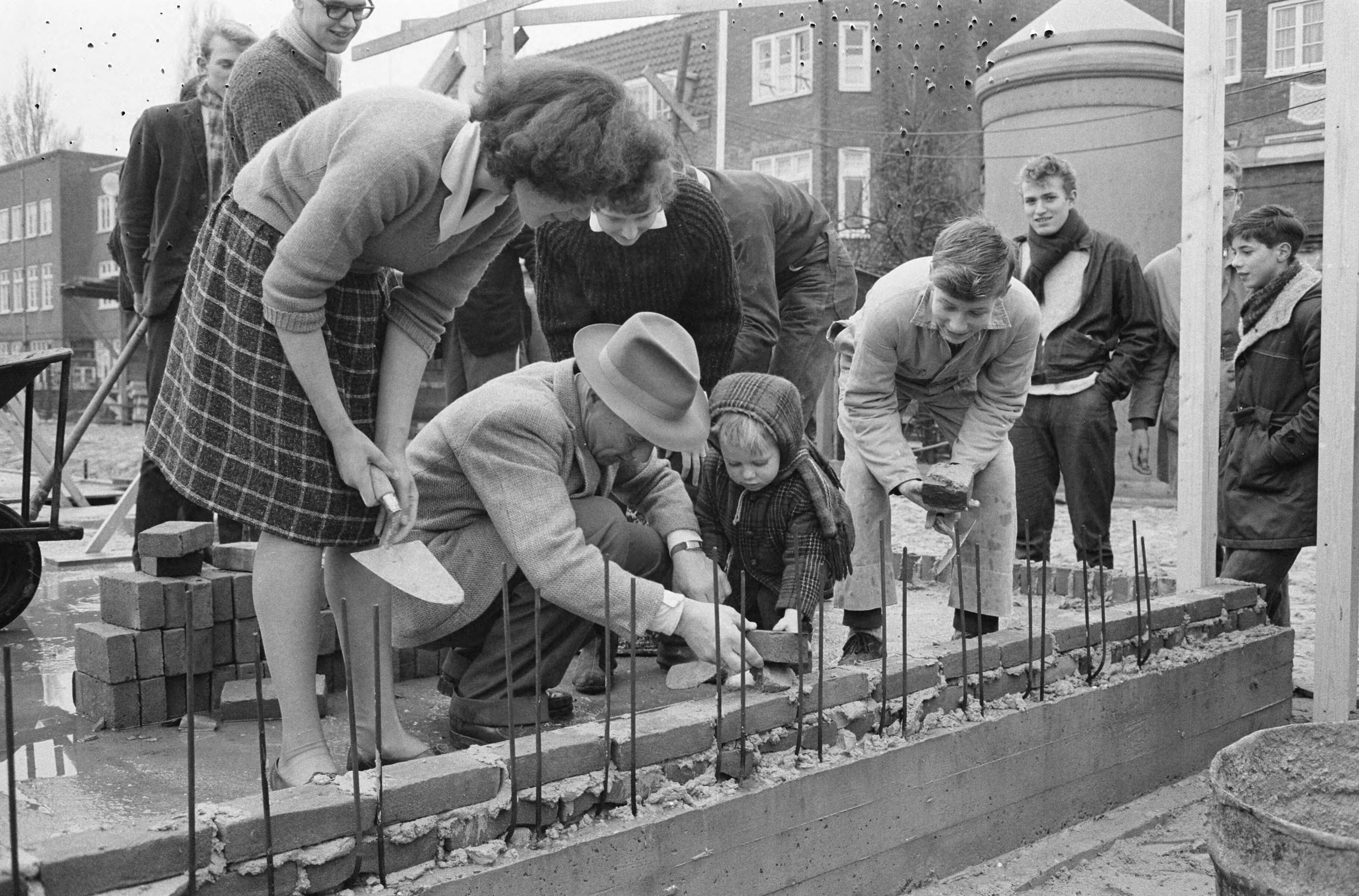 Fotocollectie Anefo — Leerlingen metselen eerste stenen van het Jeugdgebouw Noord aan de Meeuwenlaan te Amsterdam — Foto: Broers, F.N. / Anefo. Licentie: Set B: Rechtenvrij / Publiek Domein. Bron: Nationaal Archief. http://hdl.handle.net/10648/aa2370aa-d0b4-102d-bcf8-003048976d84