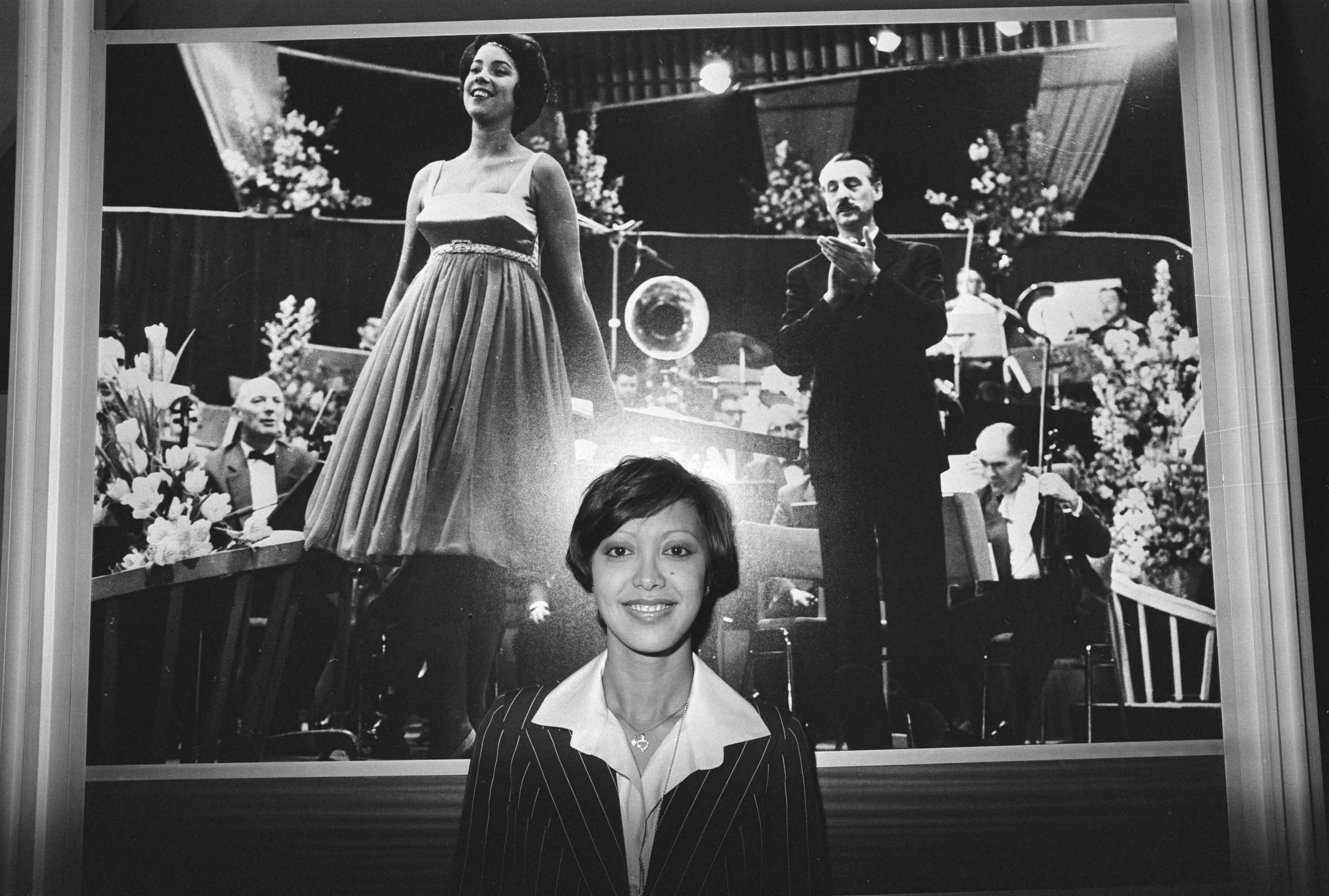 Fotocollectie Anefo — Voorbereiding Eurovisie Songfestival Den Haag ; Sandra bij foto van Corry Brokken (1952) — Foto: Mieremet, Rob / Anefo. Licentie: Set B: Rechtenvrij / Publiek Domein. Bron: Nationaal Archief. http://hdl.handle.net/10648/ac806dee-d0b4-102d-bcf8-003048976d84