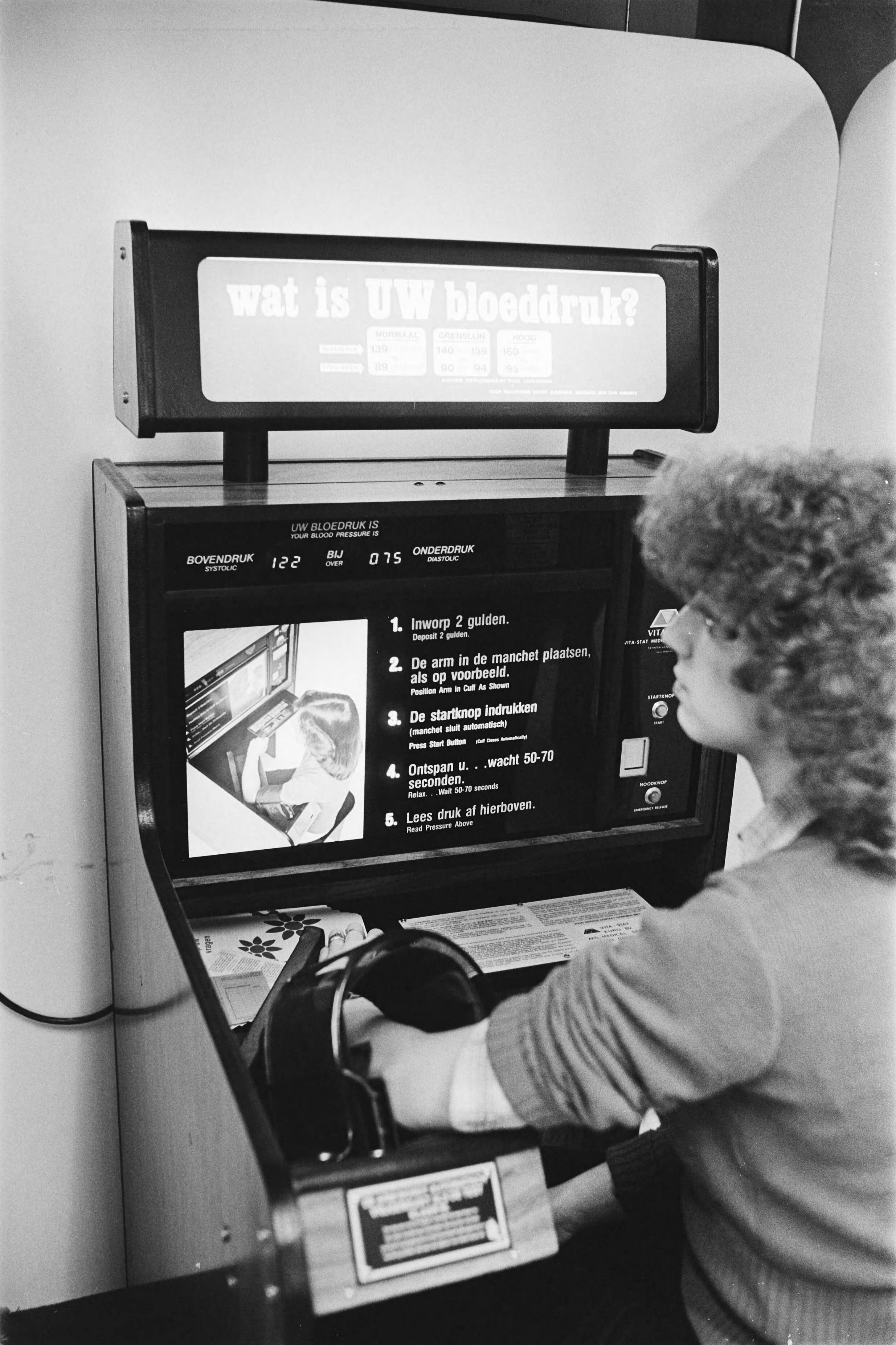 Fotocollectie Anefo — Bloeddrukmeet apparaat bij V&D in Utrecht (voor klanten) — Foto: Suyk, Koen / Anefo. Licentie: Set B: Rechtenvrij / Publiek Domein. Bron: Nationaal Archief. http://hdl.handle.net/10648/acda38c4-d0b4-102d-bcf8-003048976d84