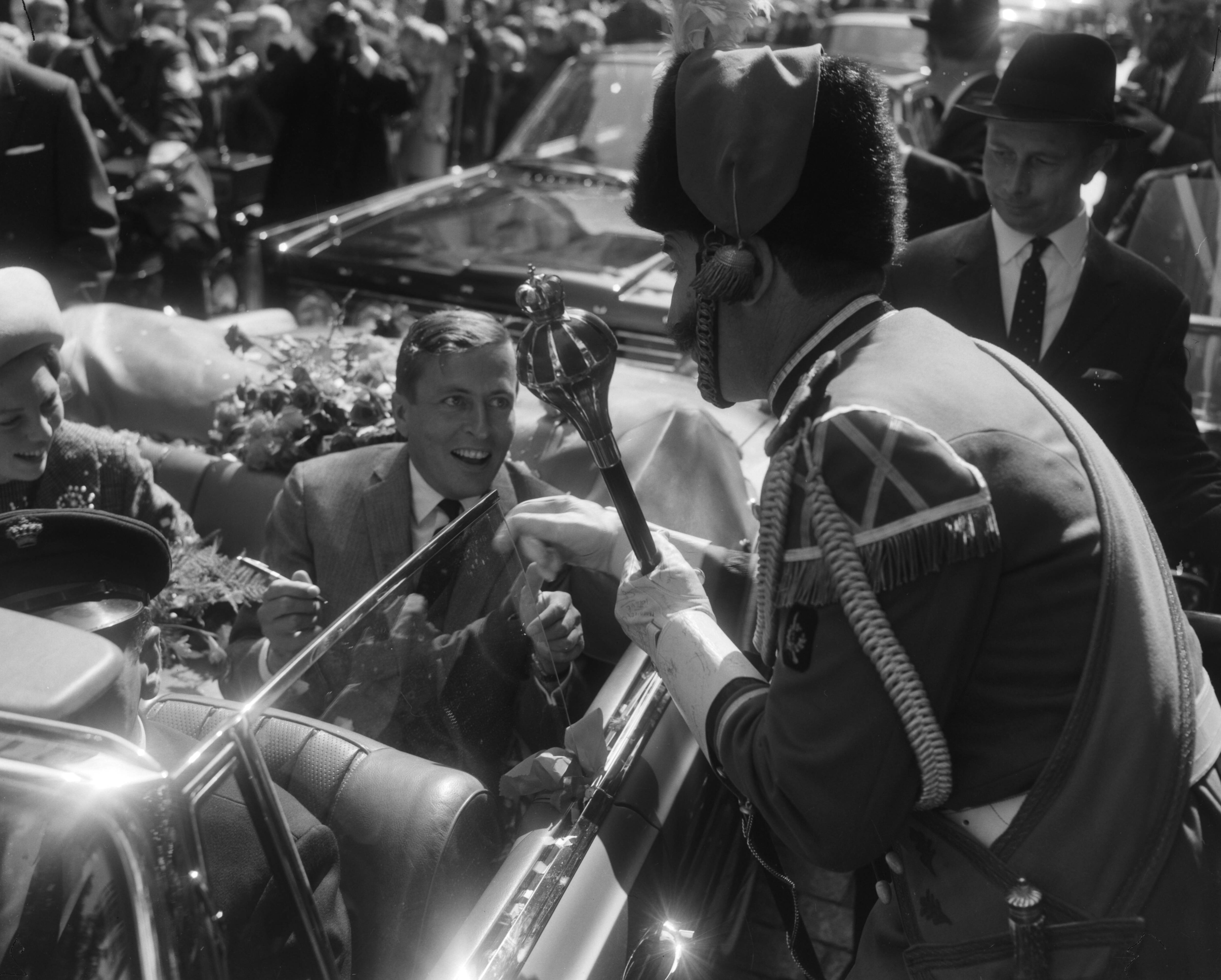 Fotocollectie Anefo — Prinses Beatrix en haar verloofde Claus von Amsberg brachten bezoek aan Maastricht, Claus von Amsbeerg zet zijn handtekening op de handschoen van een tambour-maitre — Foto: Bilsen, Joop van / Anefo. Licentie: Set B: Rechtenvrij / Publiek Domein. Bron: Nationaal Archief. http://hdl.handle.net/10648/aabfa81c-d0b4-102d-bcf8-003048976d84