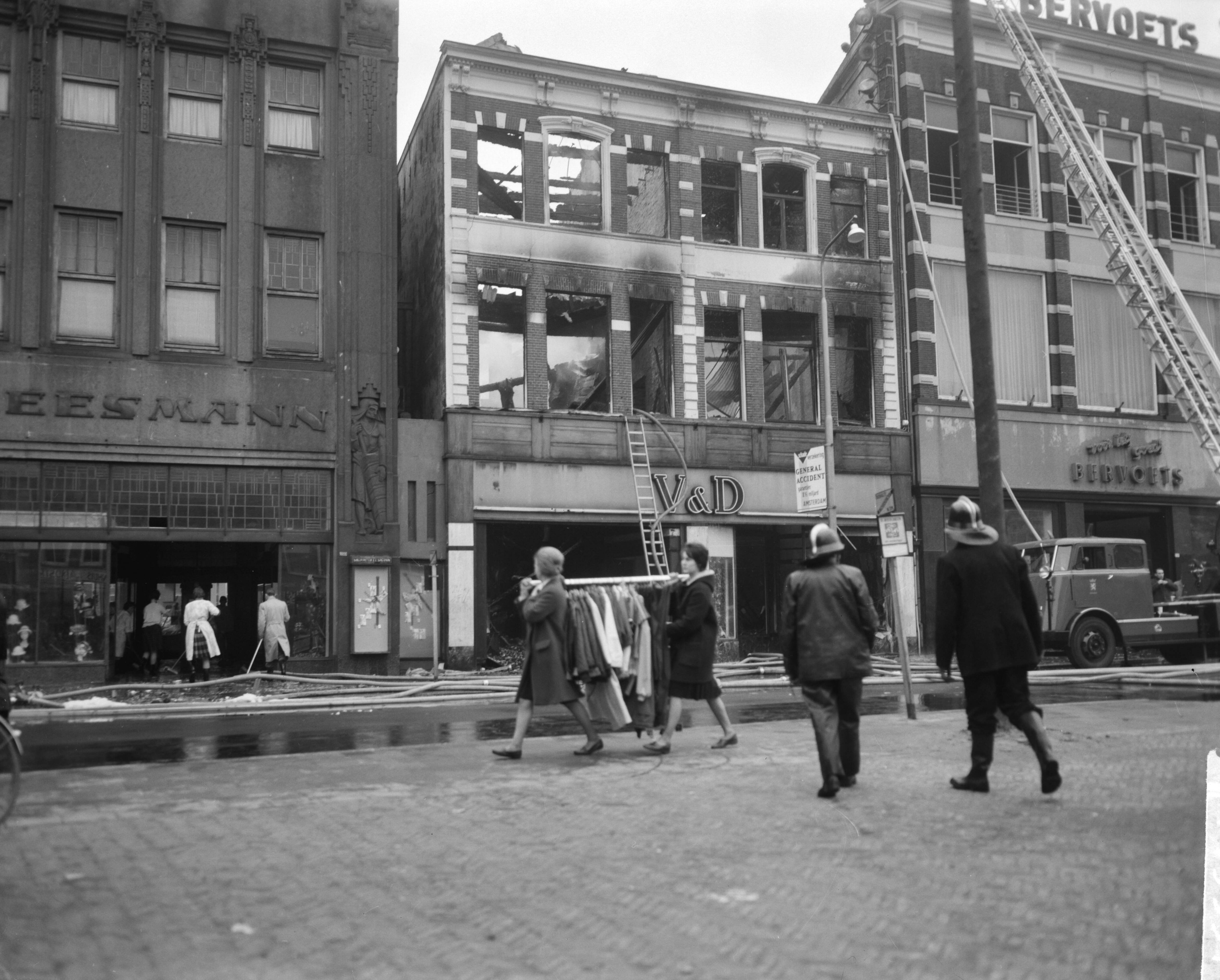 Fotocollectie Anefo — Brand bij V&D te Leeuwarden. Onbeschadigde confectie wordt in veiligheid gebracht — Foto: Bilsen, Joop van / Anefo. Licentie: Set B: Rechtenvrij / Publiek Domein. Bron: Nationaal Archief. http://hdl.handle.net/10648/aa2ed35a-d0b4-102d-bcf8-003048976d84