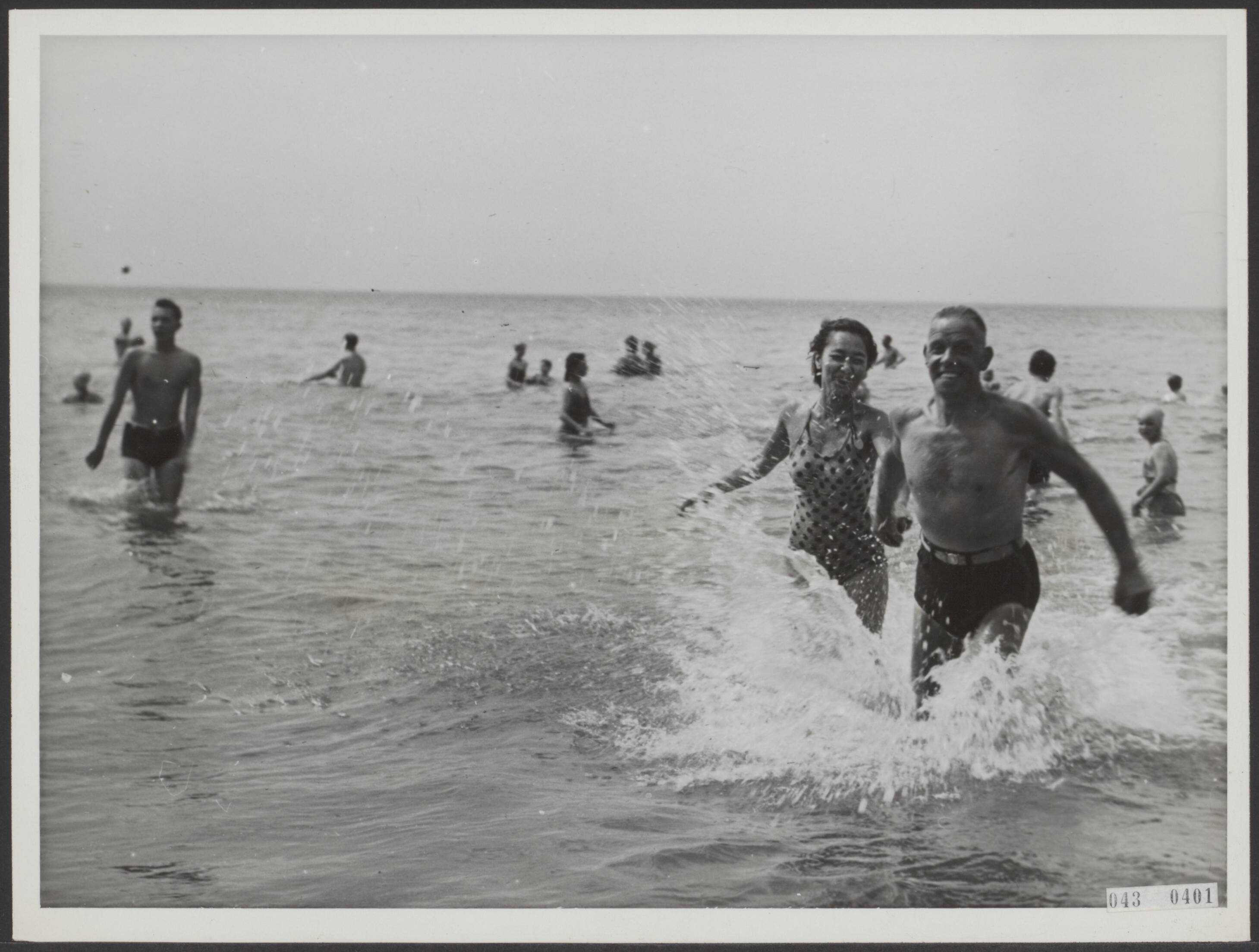 Fotocollectie Elsevier Binnenland — [Serie "Summum". over vermaak in Scheveningen] 10. Het hoogtepunt; door het water rennen als jonge kinderen — Foto: Associated Correspondents. Licentie: Set B: Rechtenvrij / Publiek Domein. Bron: Nationaal Archief. http://hdl.handle.net/10648/adf8e278-d0b4-102d-bcf8-003048976d84