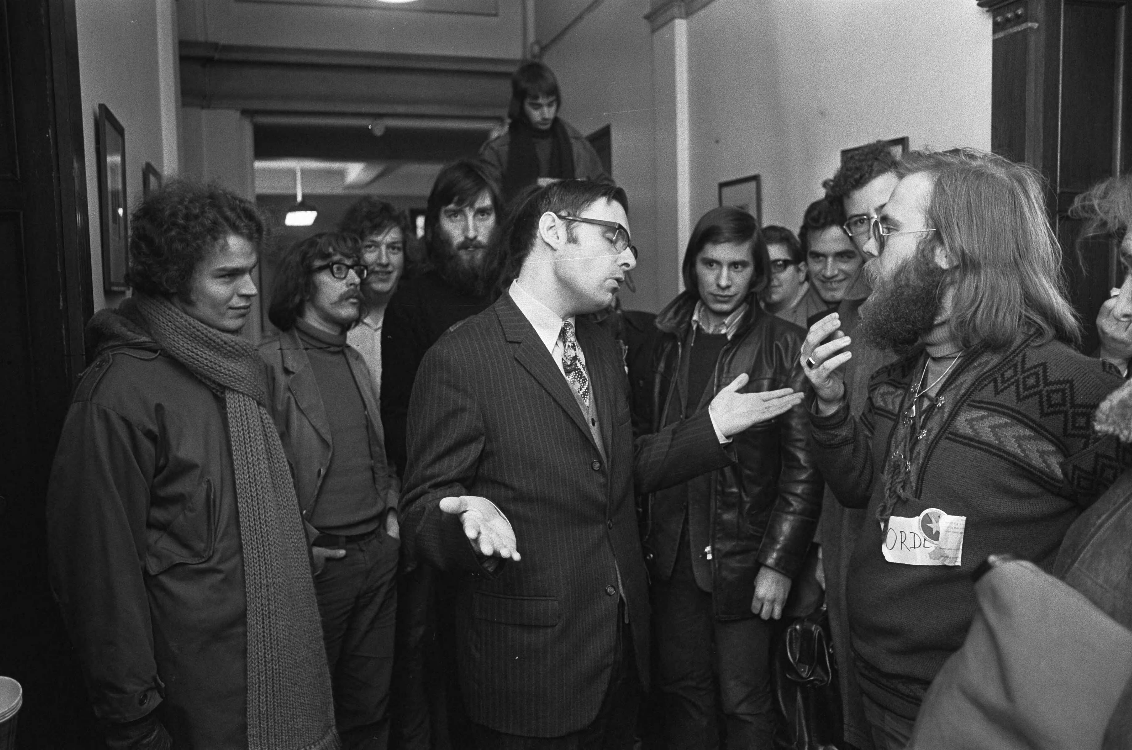 Fotocollectie Anefo — Universiteit van Utrecht bezet uit protest tegen duizend gulden collegegeld, docent die les wil geven praat met de bezetters — Foto: Peters, Hans / Anefo. Licentie: Set B: Rechtenvrij / Publiek Domein. Bron: Nationaal Archief. http://hdl.handle.net/10648/ac24d2cc-d0b4-102d-bcf8-003048976d84