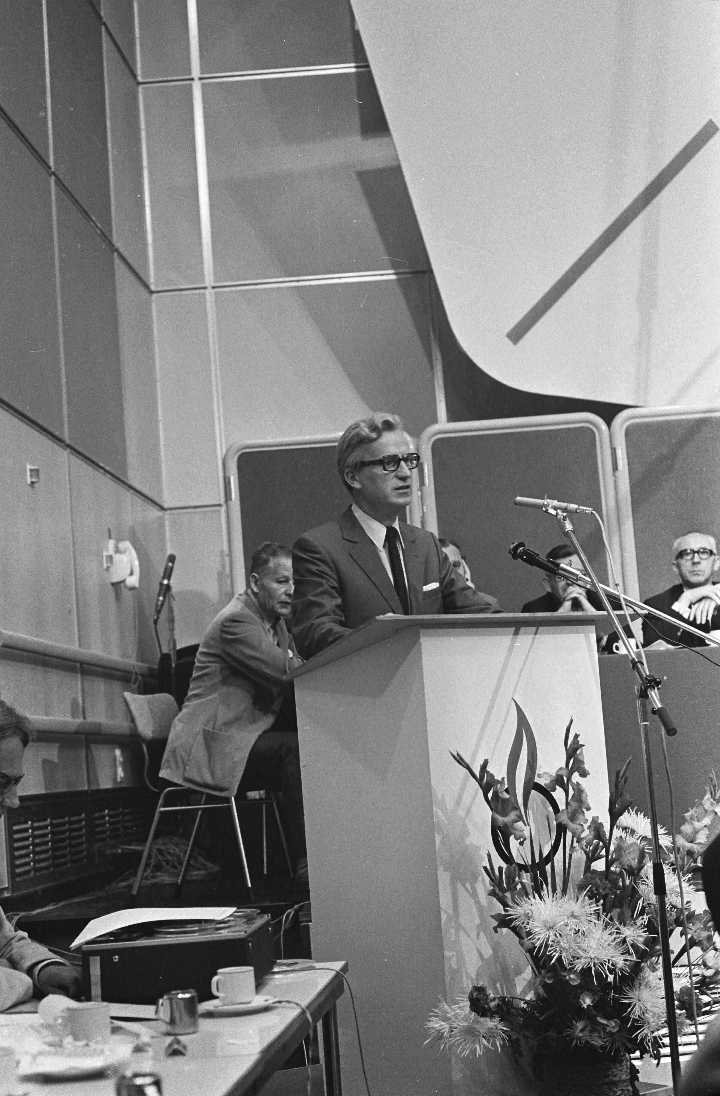 André Kloos volgt Jan Broeksz op als voorzitter van de VARA te Hilversum — Kloos aan het woord — Foto: Fotograaf Onbekend / Anefo. Licentie: Set B: Rechtenvrij / Publiek Domein. Bron: Nationaal Archief. http://hdl.handle.net/10648/abbe5f1a-d0b4-102d-bcf8-003048976d84