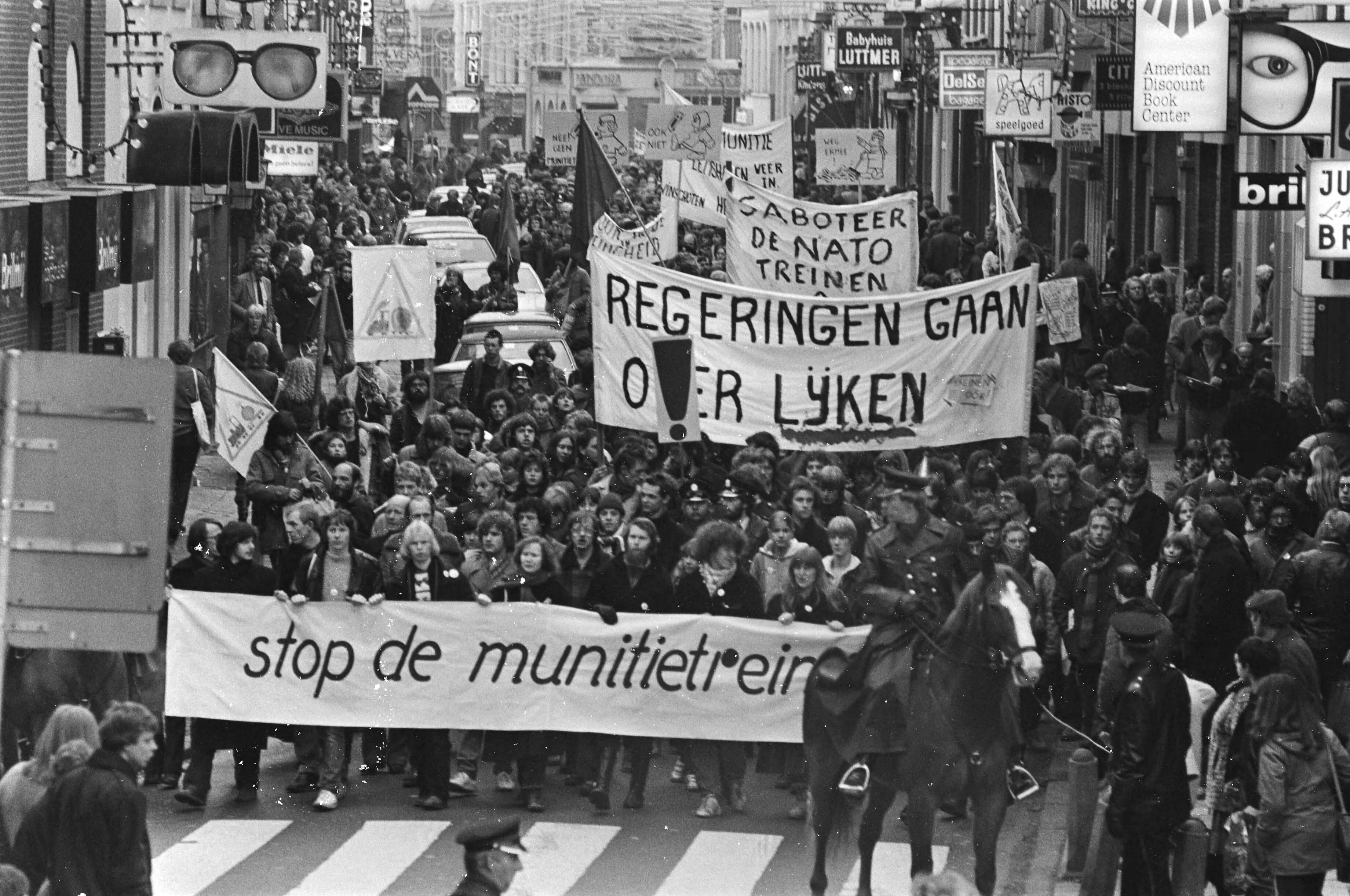 Fotocollectie Anefo — Dem. in Groningen tegen munitietransporten met treinen van de Eemshaven naar West-Duitsland. Dem. met diverse spandoeken — Foto: Bogaerts, Rob / Anefo. Licentie: Set B: Rechtenvrij / Publiek Domein. Bron: Nationaal Archief. http://hdl.handle.net/10648/ad0dfbc8-d0b4-102d-bcf8-003048976d84