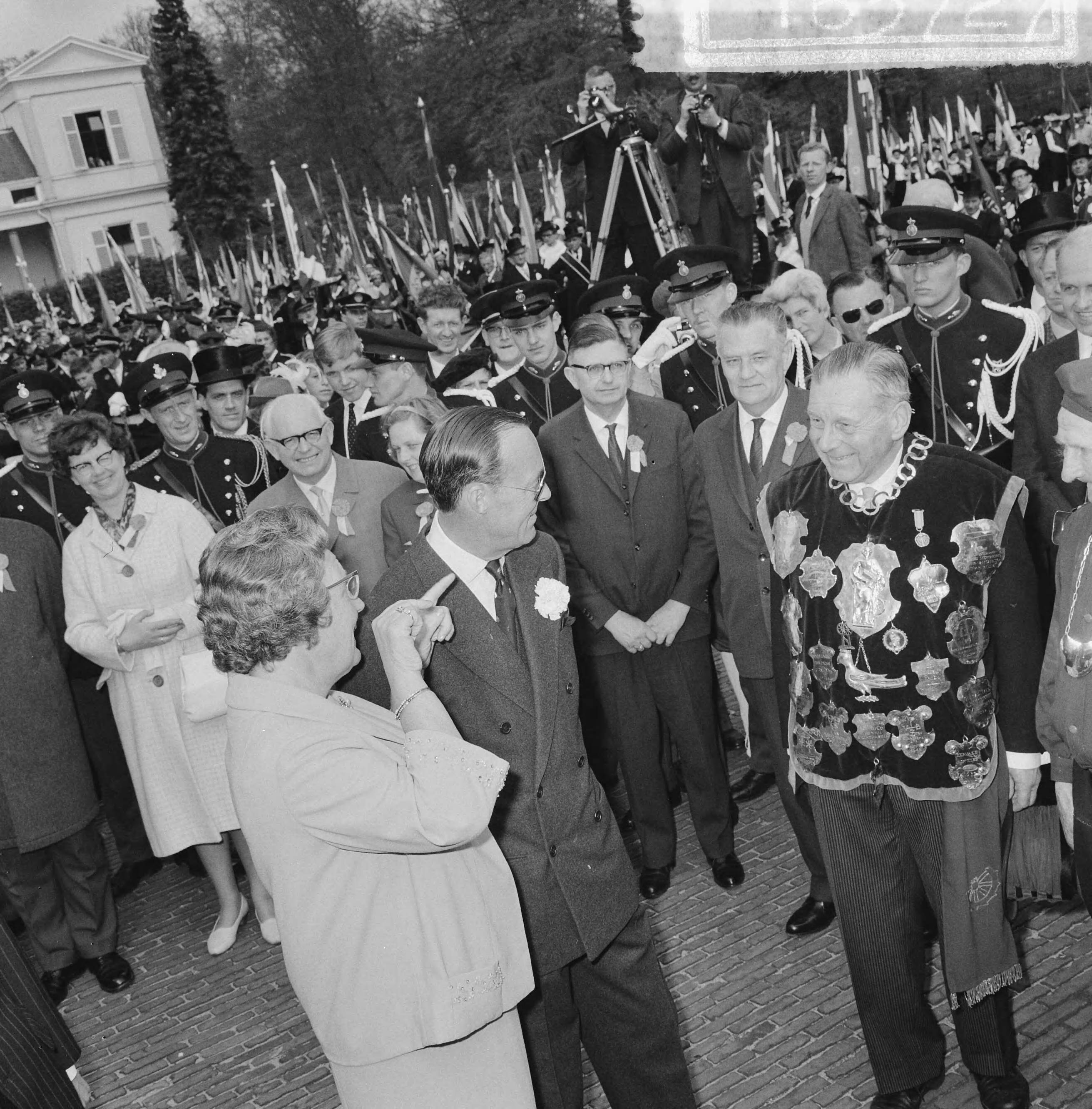 Koninginnedag 1964 — Defilé Soestdijk, Koningin Juliana en prins Bernhard in gesprek met een schutterskoning — Foto: Nijs, Jac. de / Anefo. Licentie: Set B: Rechtenvrij / Publiek Domein. Bron: Nationaal Archief. http://hdl.handle.net/10648/aa66d98a-d0b4-102d-bcf8-003048976d84