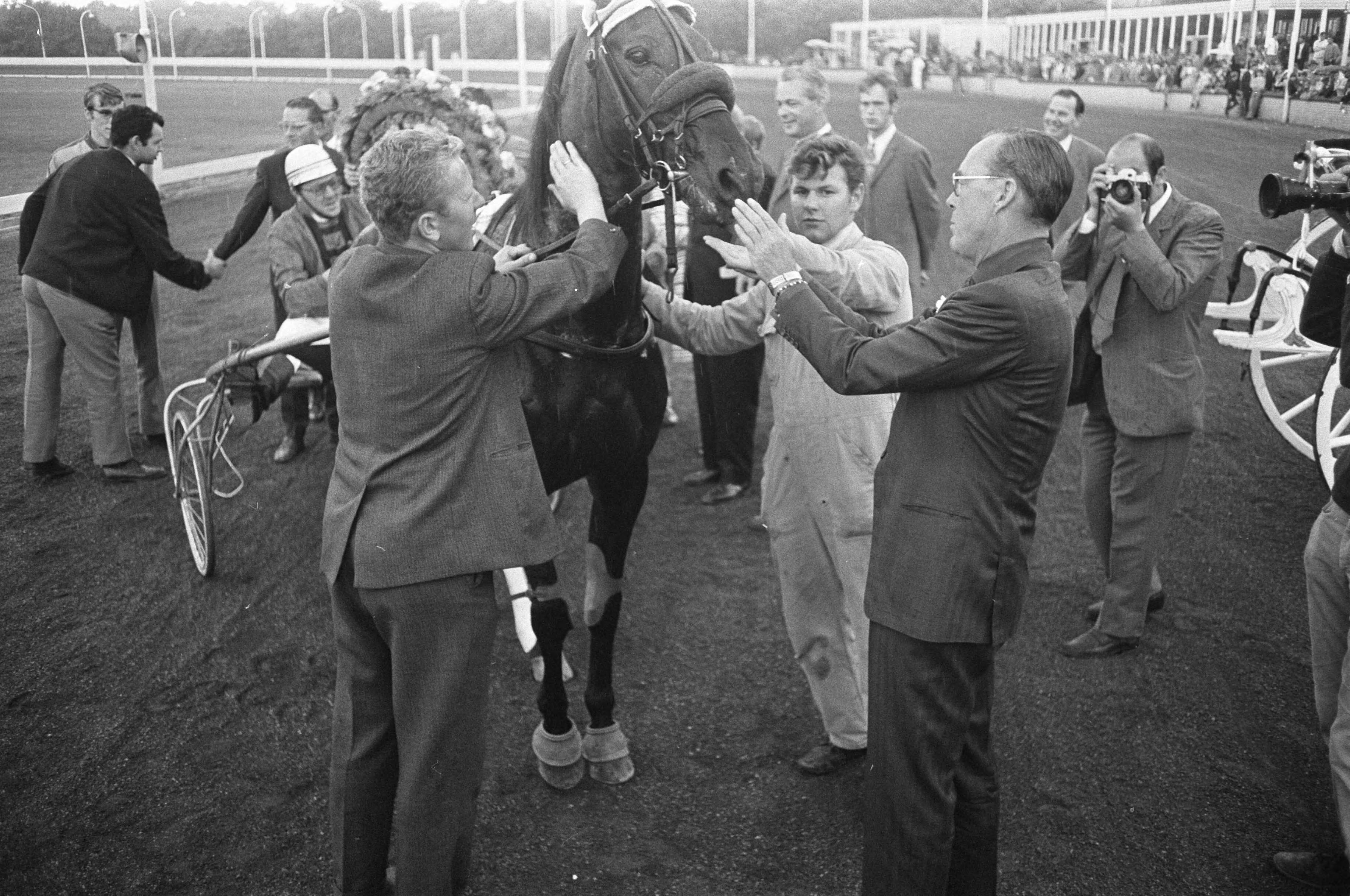 Draverijen om de Gouden Zweep te Hilversum — Prins Bernhard bij winnaar pikeur J. V. Dooyeweerd — Foto: Fotograaf Onbekend / Anefo. Licentie: Set B: Rechtenvrij / Publiek Domein. Bron: Nationaal Archief. http://hdl.handle.net/10648/ab71a5ee-d0b4-102d-bcf8-003048976d84