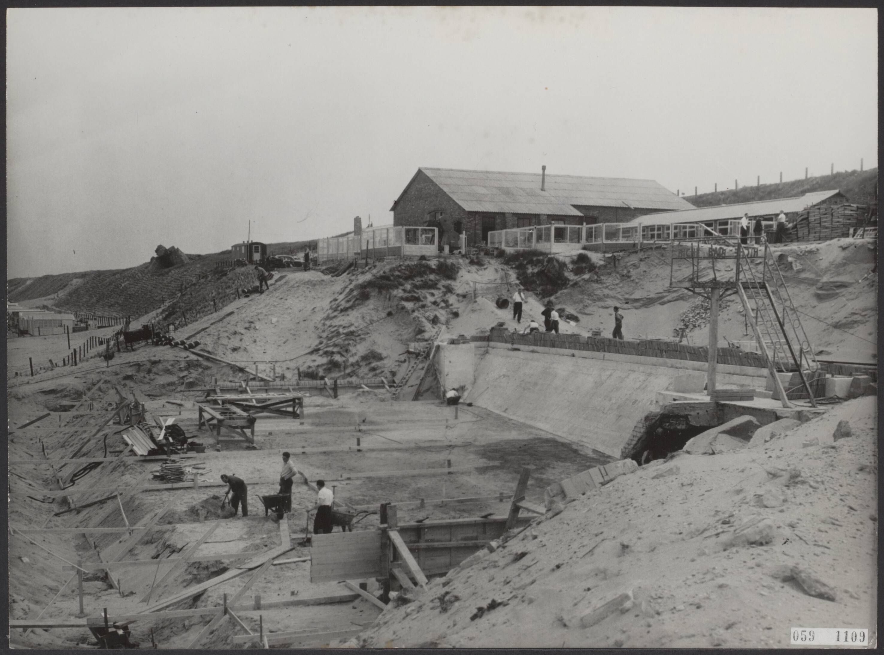 Fotocollectie Elsevier Binnenland — Zandvoort herstelt zich van de stormramp op 1 februari 1953 en bereidt zich voor op het badseizoen. Het Riche-bad aan de Boulevard de Favauge (Noordboulevard) wordt weer in orde gebracht. Over enige weken zal het weer worden opengesteld — Foto: Pot, Harry / Anefo. Licentie: Set B: Rechtenvrij / Publiek Domein. Bron: Nationaal Archief. http://hdl.handle.net/10648/ae0c47b4-d0b4-102d-bcf8-003048976d84