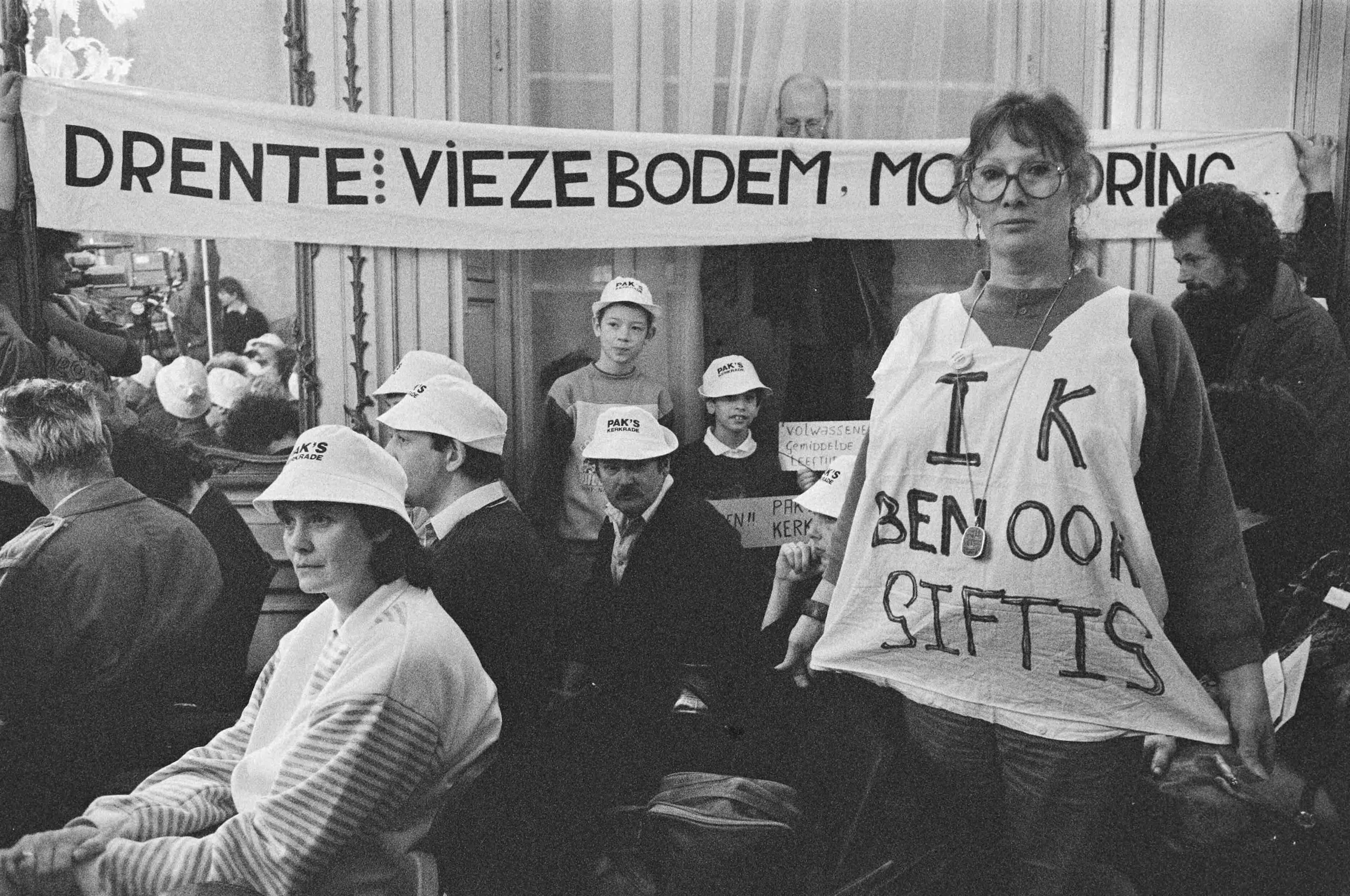 Bewoners van gifbelten spreken in Den Haag met minister Nijpels — Bewoners in actietenue met spandoeken en petjes — Foto: Croes, Rob C. / Anefo. Licentie: Set B: Rechtenvrij / Publiek Domein. Bron: Nationaal Archief. http://hdl.handle.net/10648/ad70ef44-d0b4-102d-bcf8-003048976d84