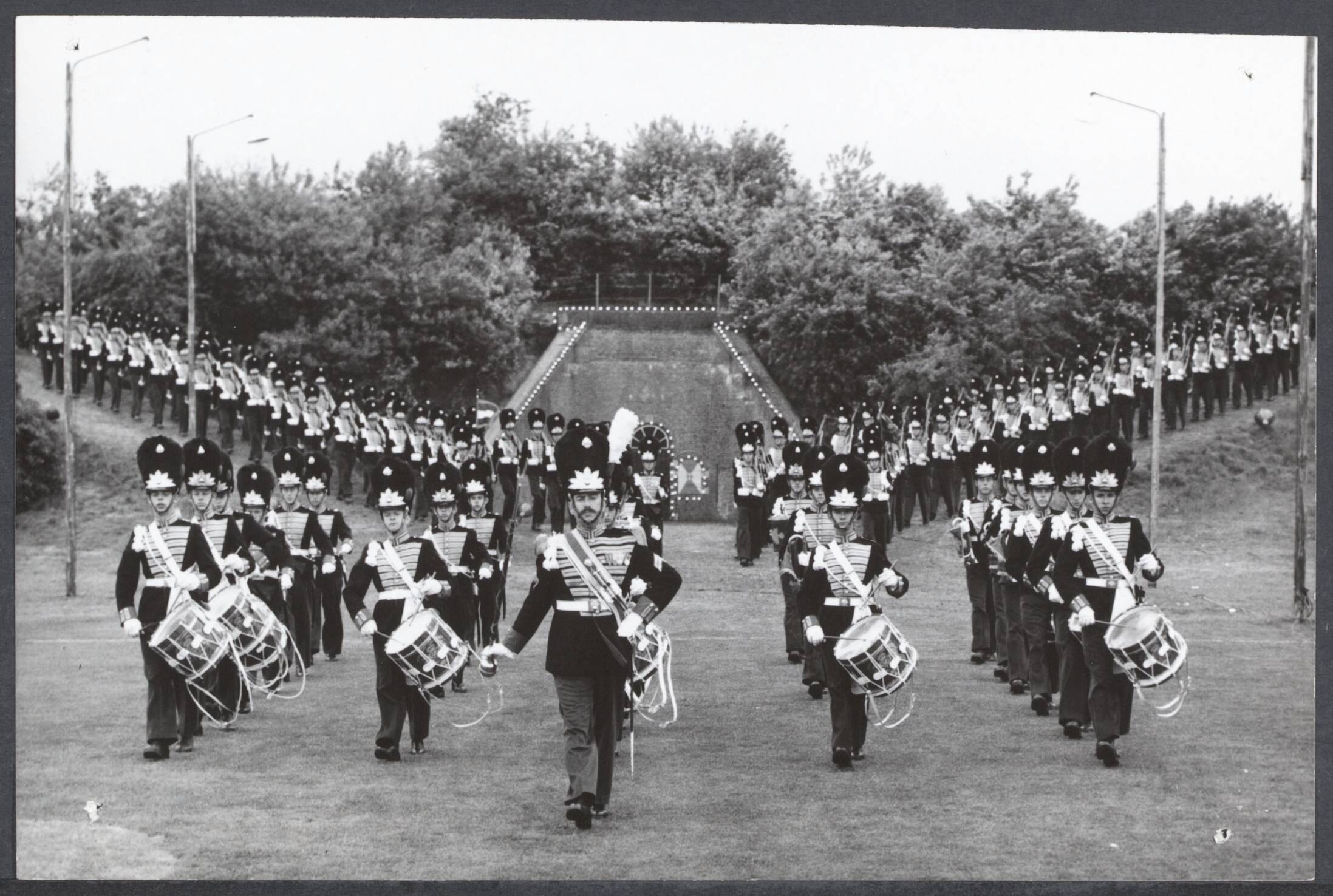 Parades, inspecties leger na 1945 - Nederland / Internationaal — Generale repetitie van de Militaire Taptoe in Bussum in Sportpark Zuid ten aanschouwe van honderden schoolkinderen. De Koningscompagnie van de Grenadiers uit Arnhem komen het oude fort afmarcheren voor hun muzikale show — Foto: Rossem, Wim van / Anefo. Licentie: Set B: Rechtenvrij / Publiek Domein. Bron: Nationaal Archief. http://hdl.handle.net/10648/d1605d40-9c7f-4310-8642-01f2ad7ec7bc