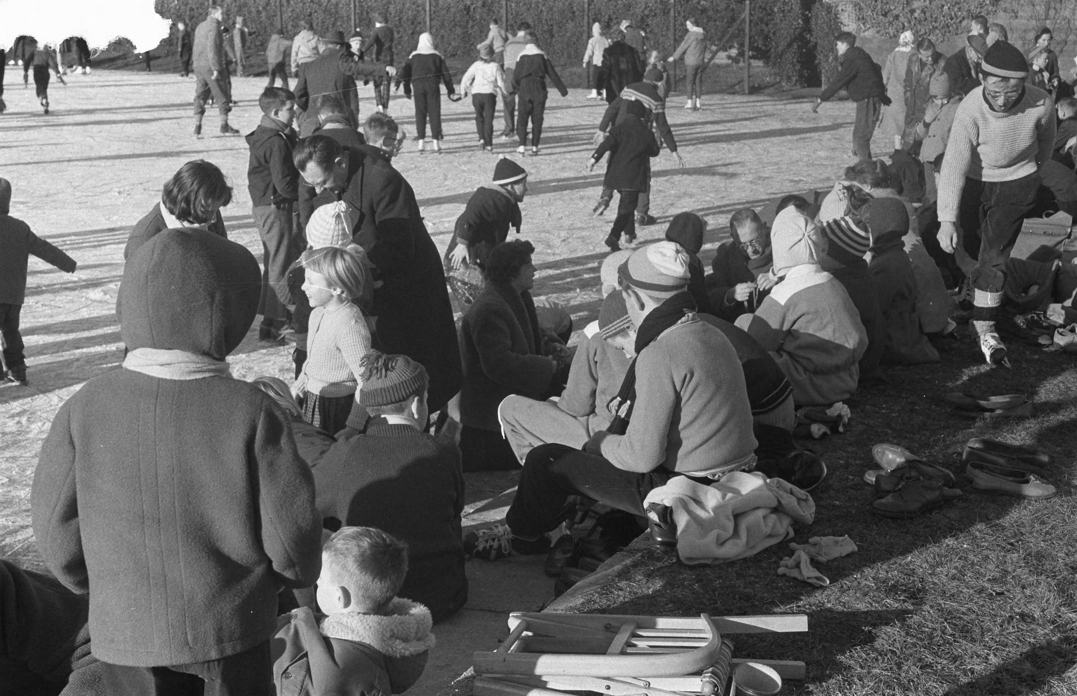 Fotocollectie Anefo — Schaatsen op ondergespoten tennisbanen in Den Haag, onderbinden van de schaatsen — Foto: Pot, Harry / Anefo. Licentie: Set B: Rechtenvrij / Publiek Domein. Bron: Nationaal Archief. http://hdl.handle.net/10648/a9a55a1c-d0b4-102d-bcf8-003048976d84