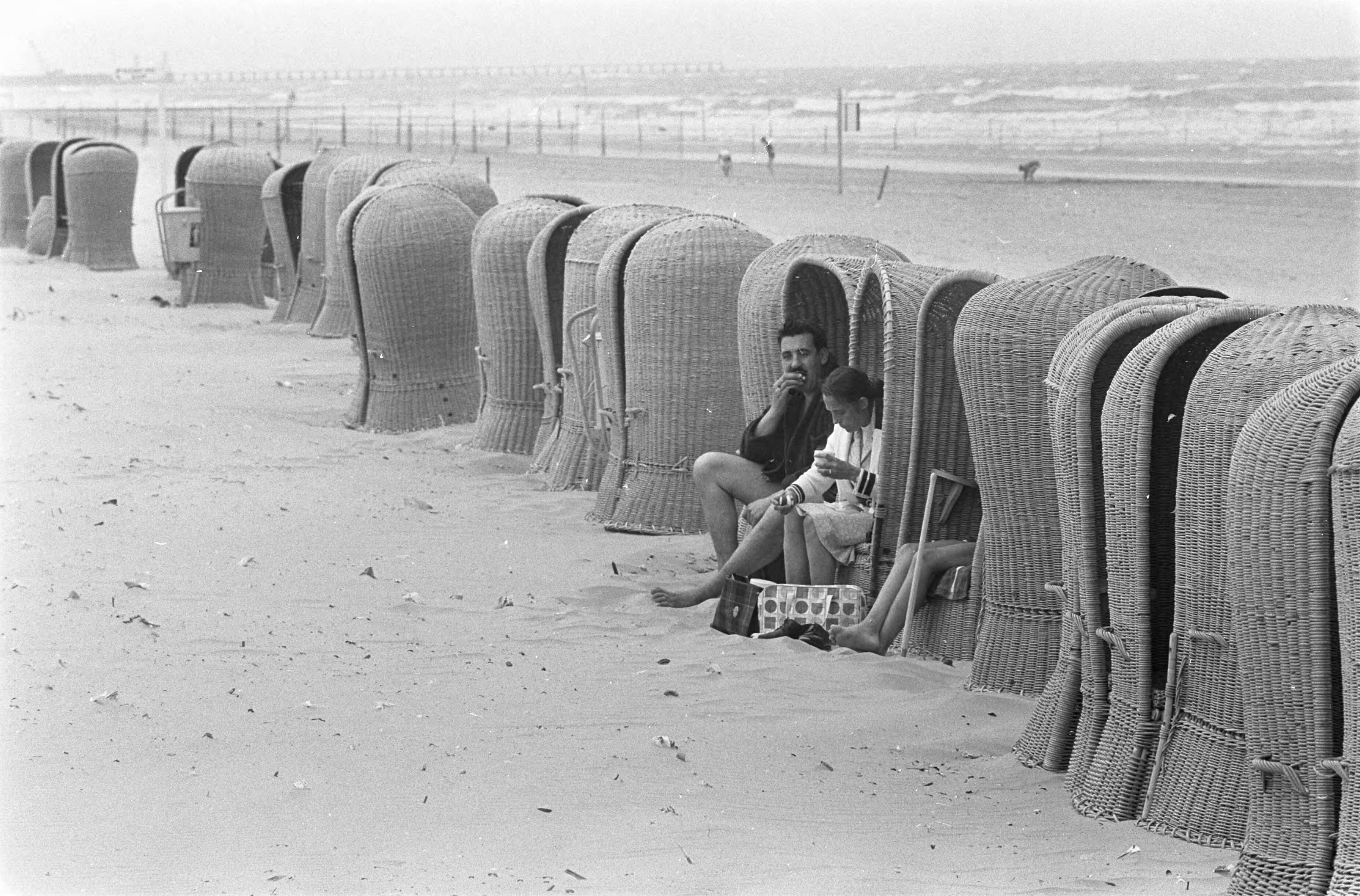 Zomer 1967 — Enthousiaste buitenlanders zoeken een plaatsje uit de wind — Foto: Fotograaf Onbekend / Anefo. Licentie: Set B: Rechtenvrij / Publiek Domein. Bron: Nationaal Archief. http://hdl.handle.net/10648/ab1d9fbc-d0b4-102d-bcf8-003048976d84