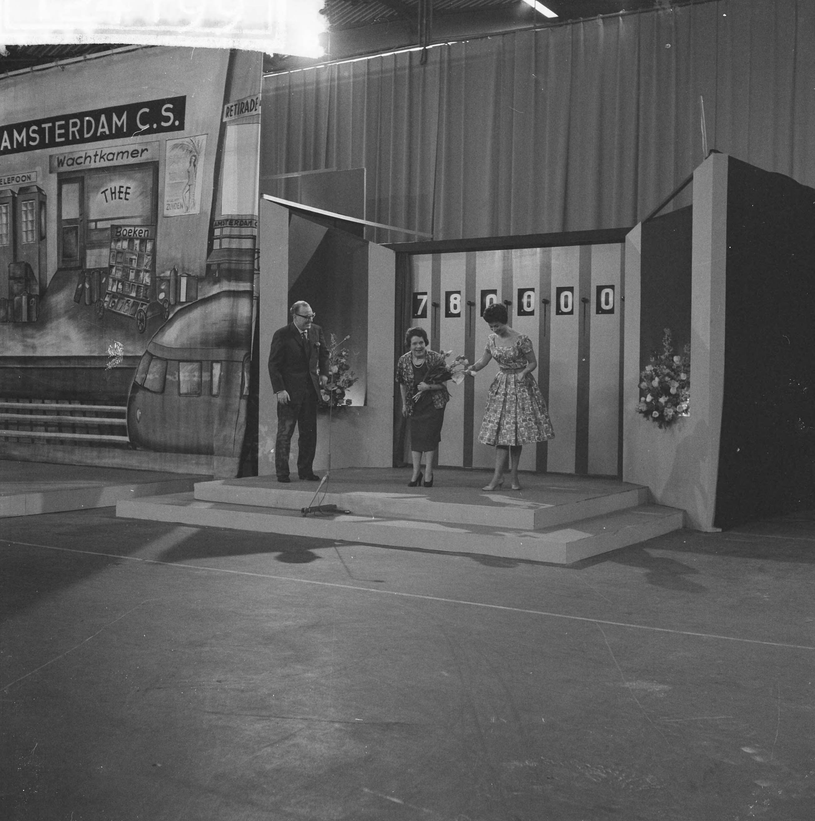 Fotocollectie Anefo — Televisieprogramma "TV-Toto" vanuit de Expohal te Hilversum. Vlnr. presentator Theo Eerdmans, Julia de Gruyter en assistente Maud — Foto: Lindeboom, Henk / Anefo. Licentie: Set B: Rechtenvrij / Publiek Domein. Bron: Nationaal Archief. http://hdl.handle.net/10648/a9d34968-d0b4-102d-bcf8-003048976d84