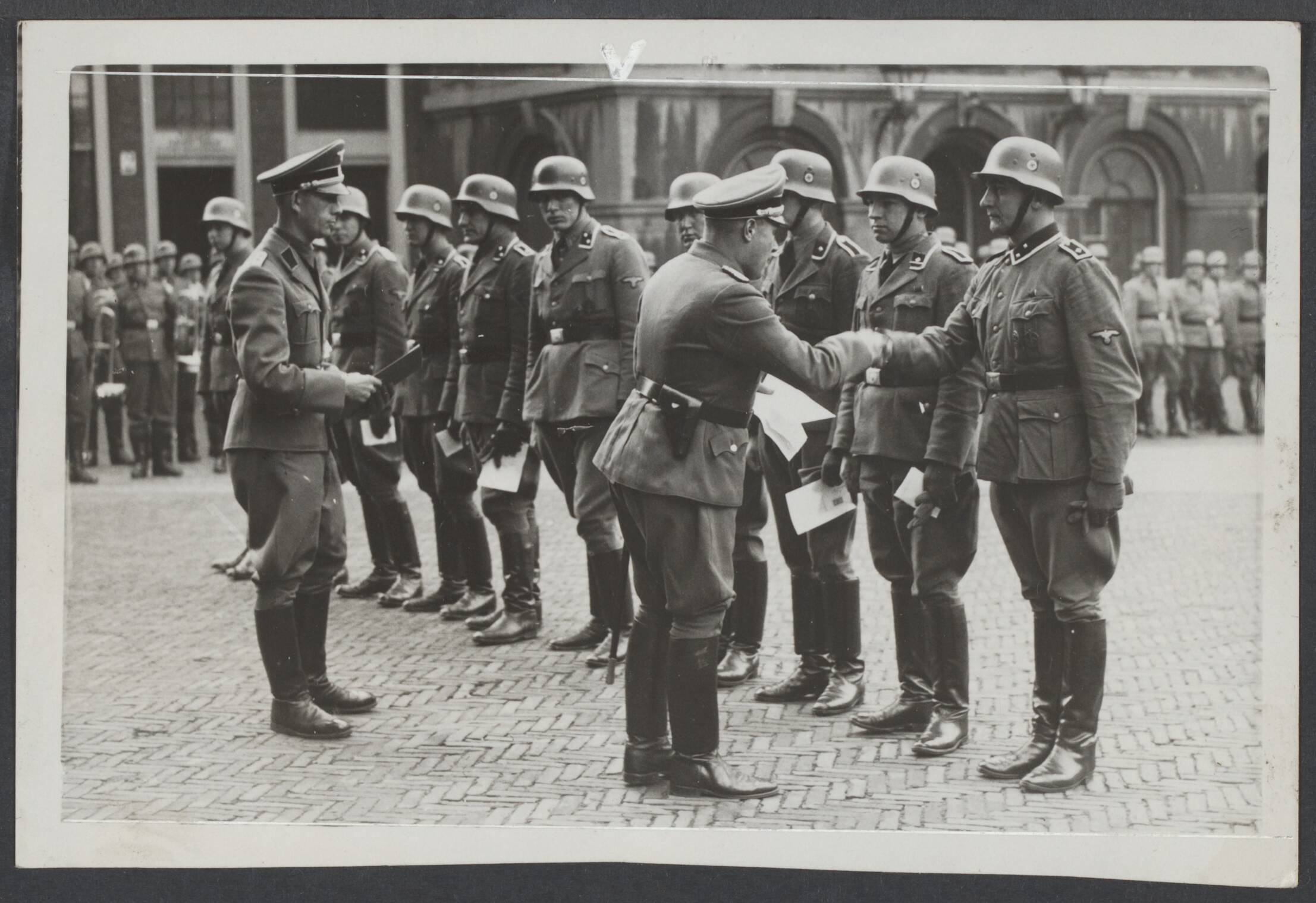 Vrijwilligers Legioen Nederland — Op het Binnenhof te Den Haag zijn een aantal leden van de SS bevorderd, terwijl tevens aan een van hen het IJzeren Kruis 2e klasse werd uitgereikt. — Foto: N.V. Polygoon. Licentie: Set B: Rechtenvrij / Publiek Domein. Bron: Nationaal Archief. http://hdl.handle.net/10648/a1073263-aee5-c403-3c36-6d816bf66719