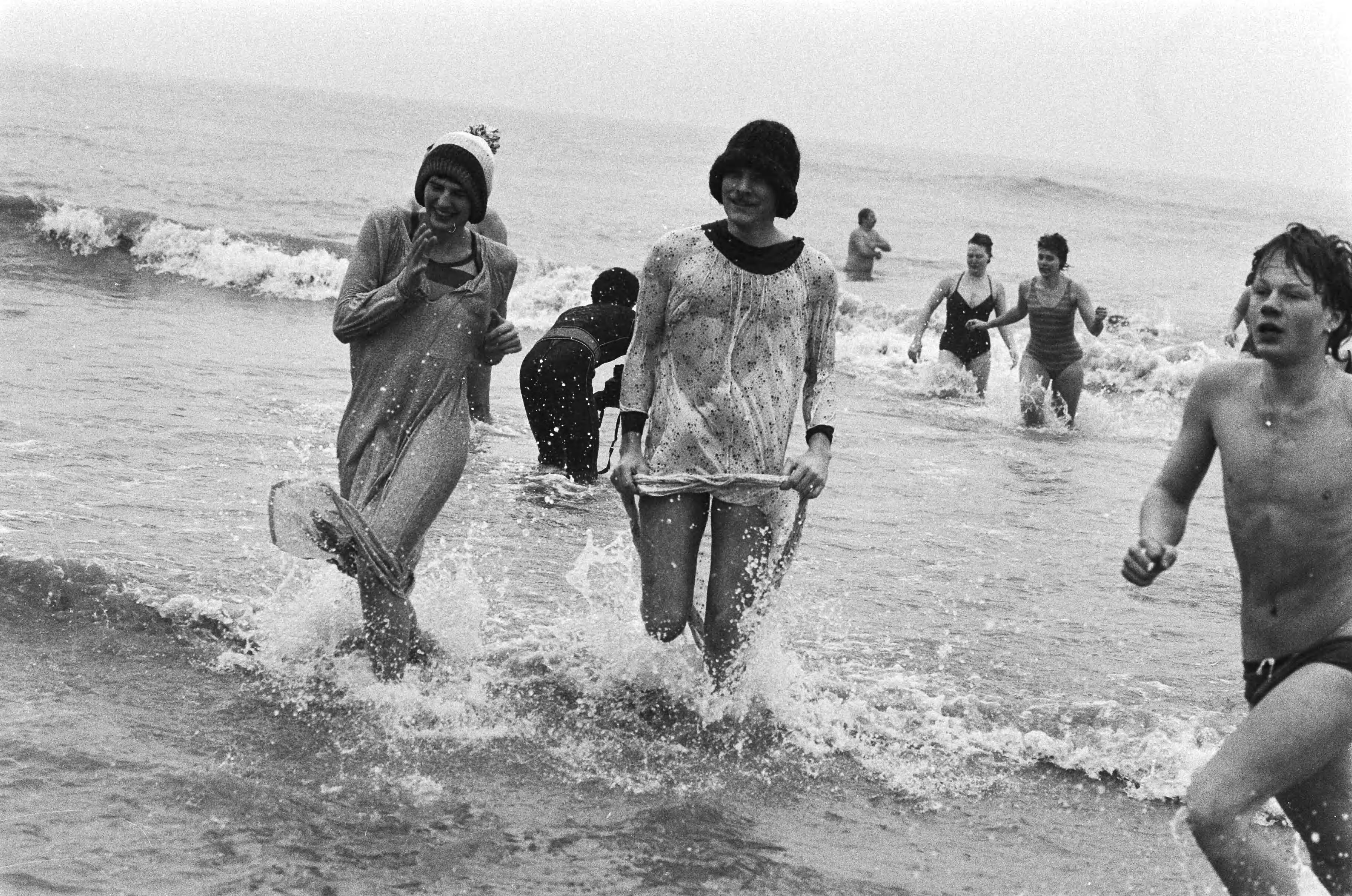 Traditionele Nieuwjaarsduik in Scheveningen — Mensen rennen terug uit het koude water — Foto: Bogaerts, Rob / Anefo. Licentie: Set B: Rechtenvrij / Publiek Domein. Bron: Nationaal Archief. http://hdl.handle.net/10648/ad4e3cba-d0b4-102d-bcf8-003048976d84